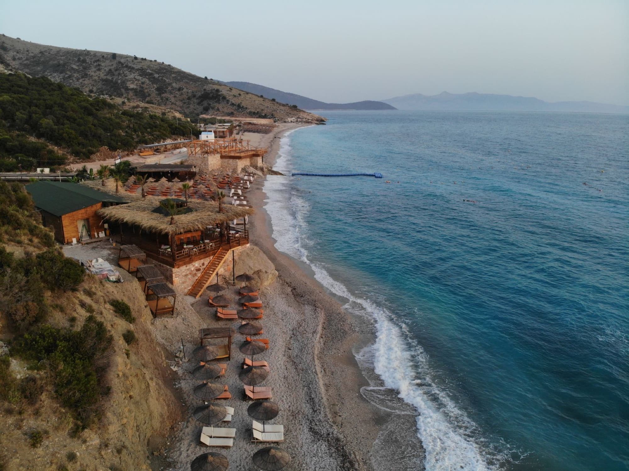 Stunning aerial shot of a serene beach resort in Albania, featuring turquoise waters and scenic coastline.