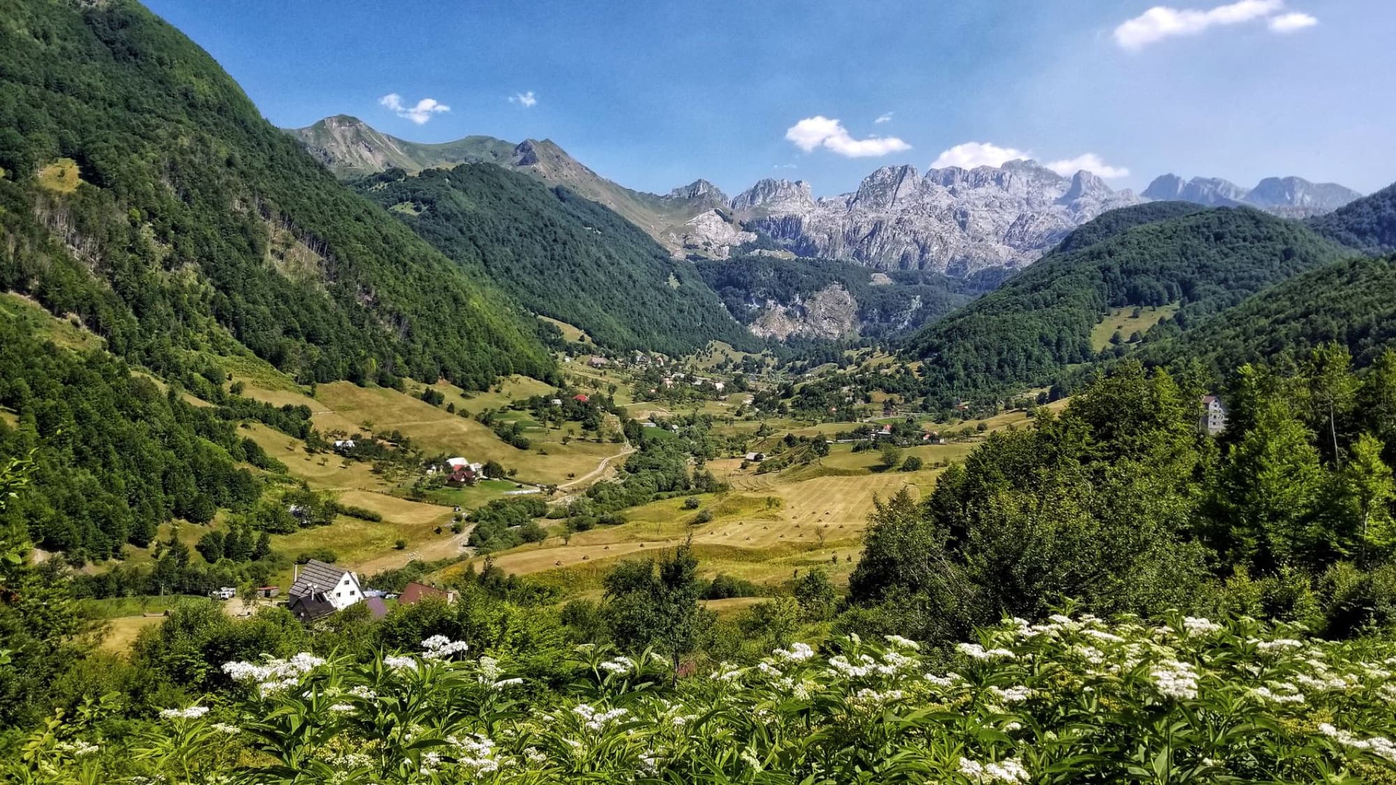 Beautiful Albanian valley landscape with mountains, forests, and a picturesque village.