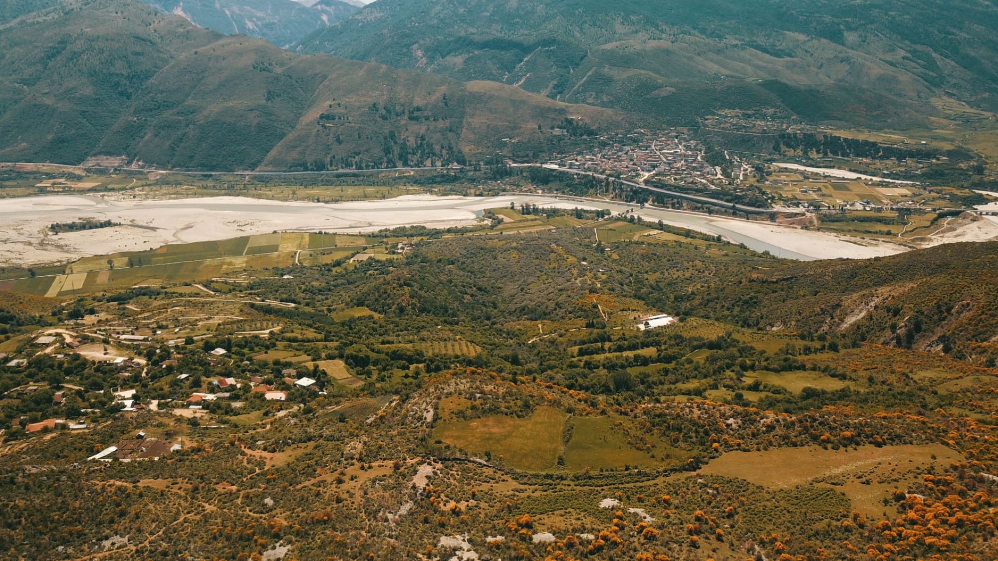 A breathtaking aerial panorama of Tepelenë's lush valley and mountainous backdrop in Albania.