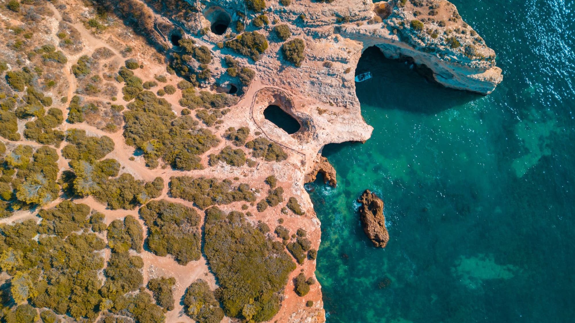 Stunning aerial view of the scenic Algarve coastline with natural caves and turquoise water.