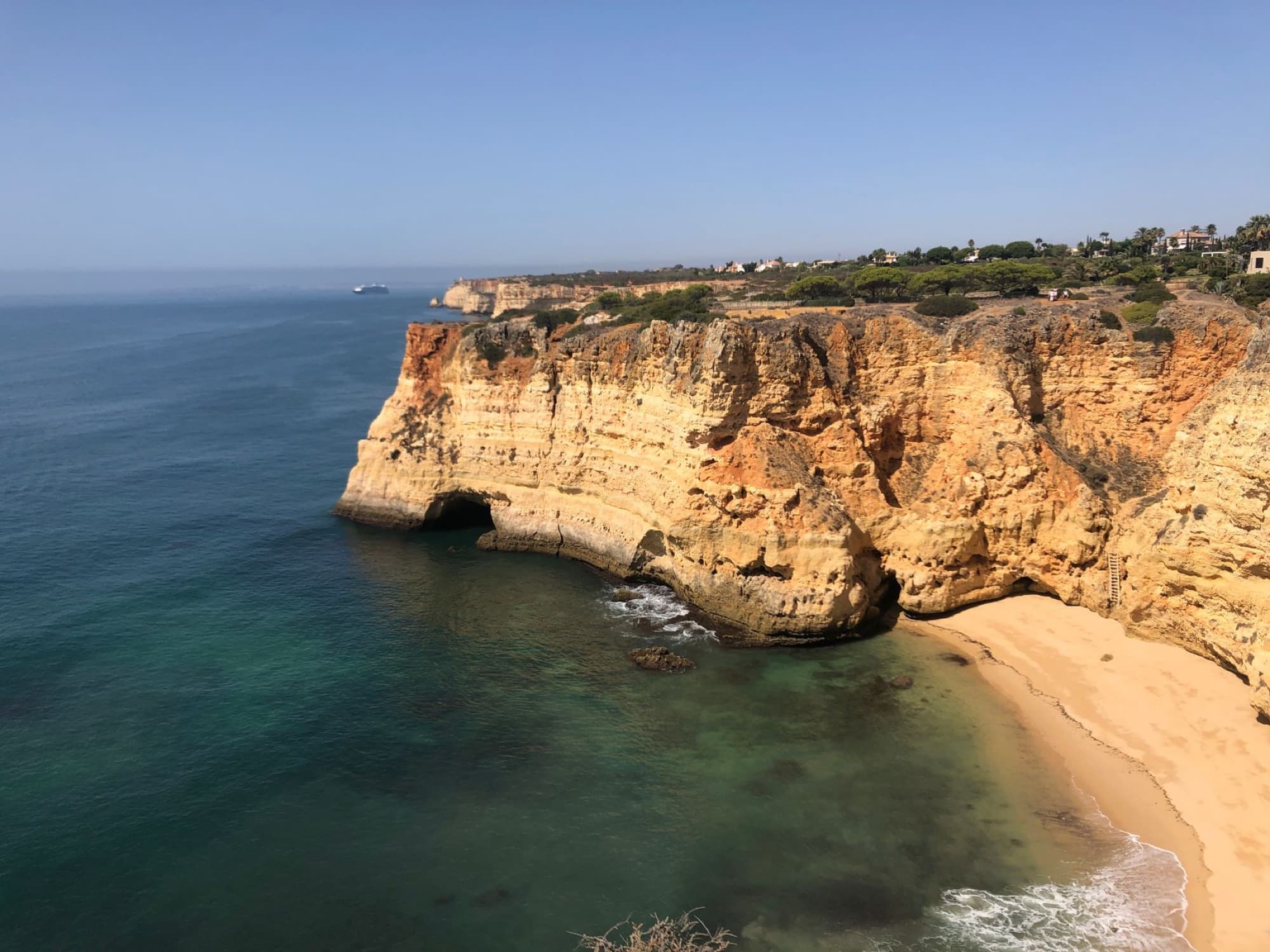 A breathtaking view of the Algarve coastline featuring dramatic cliffs and a serene beach in Portugal.