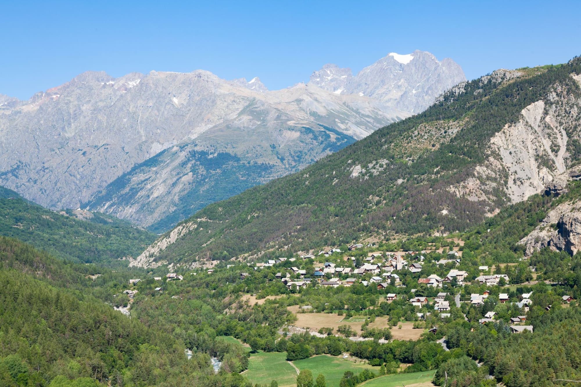 A stunning aerial view of the village Vallouise-Pelvoux in the French Alps with lush greenery and majestic mountains.