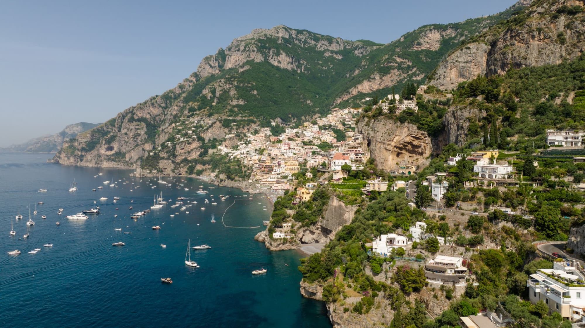 Scenic aerial view of the Amalfi coastline with vibrant cliffs, blue sea, and charming towns.