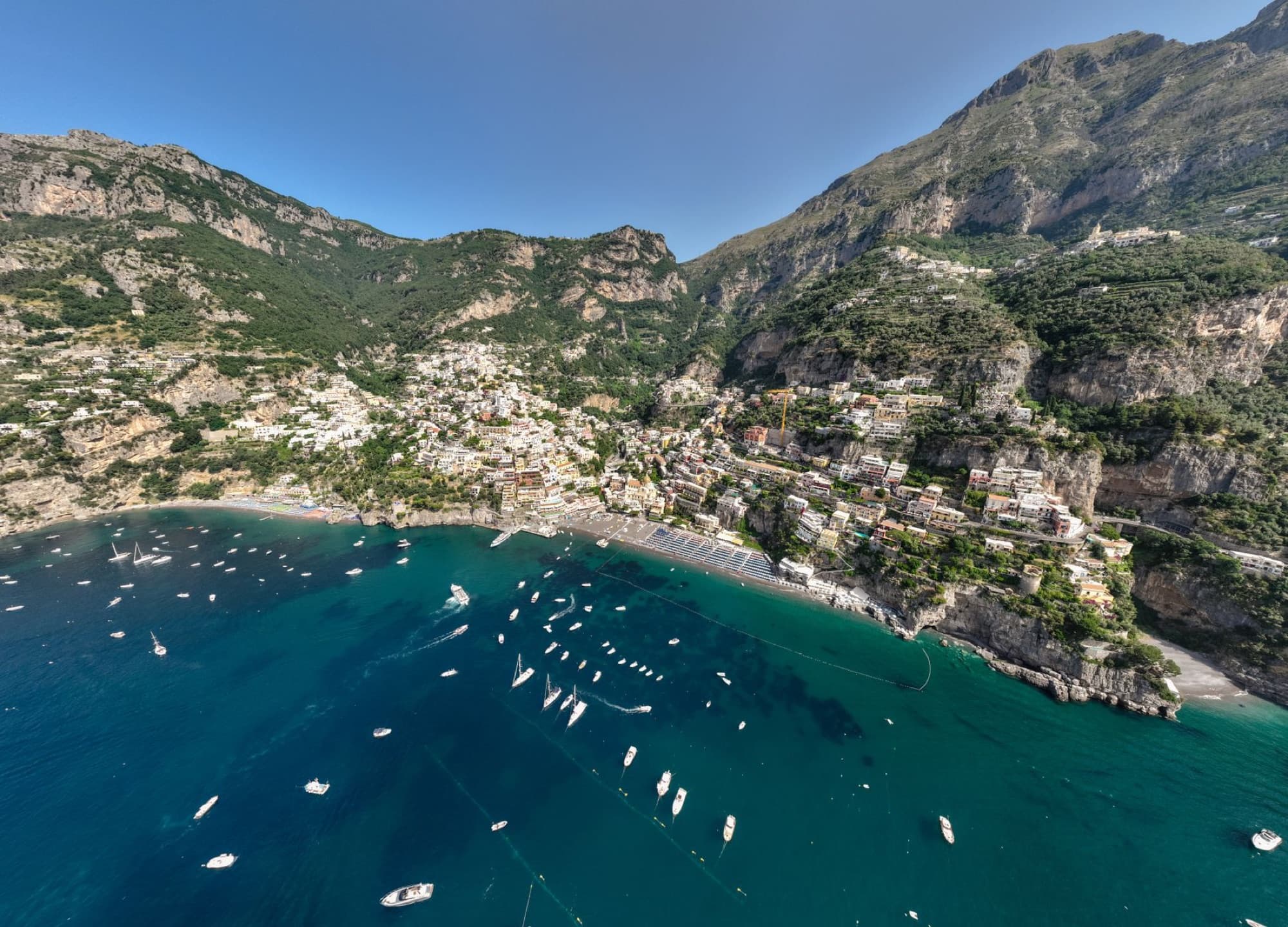 Stunning aerial shot of Positano village with boats along the Amalfi Coast.