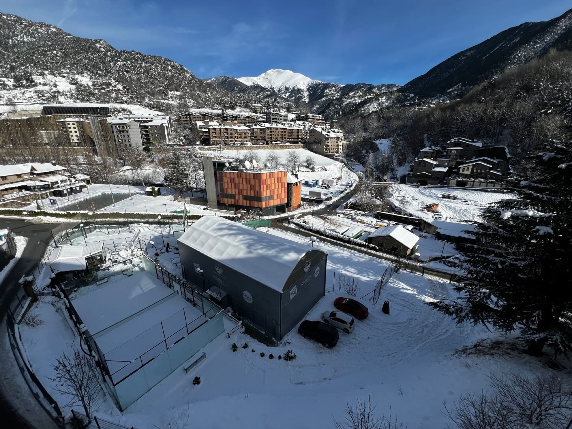 Aerial view of a snowy mountain town in Andorra during winter.