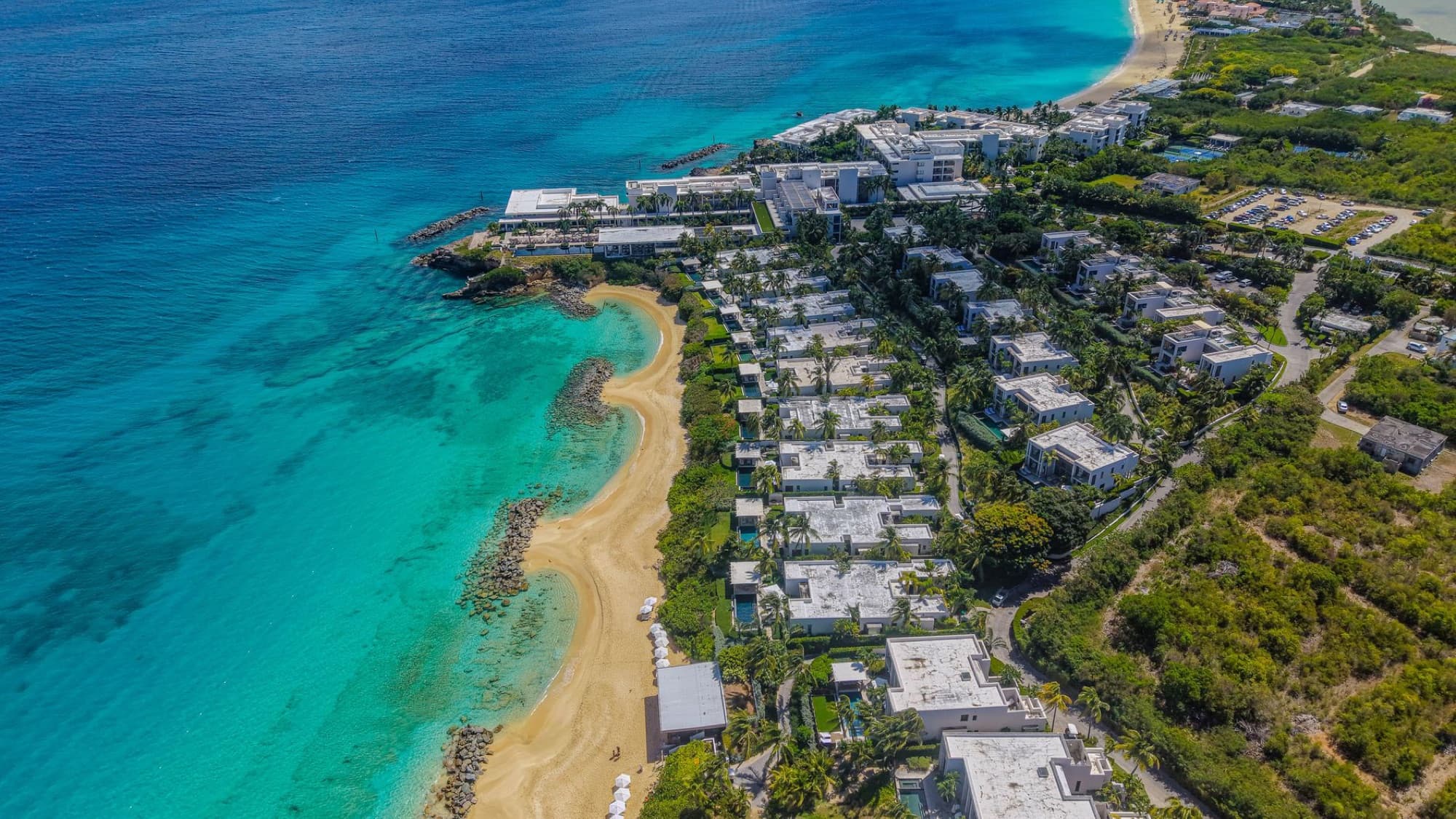 A breathtaking aerial shot showcasing the coastline and luxury resorts of Anguilla with turquoise waters.