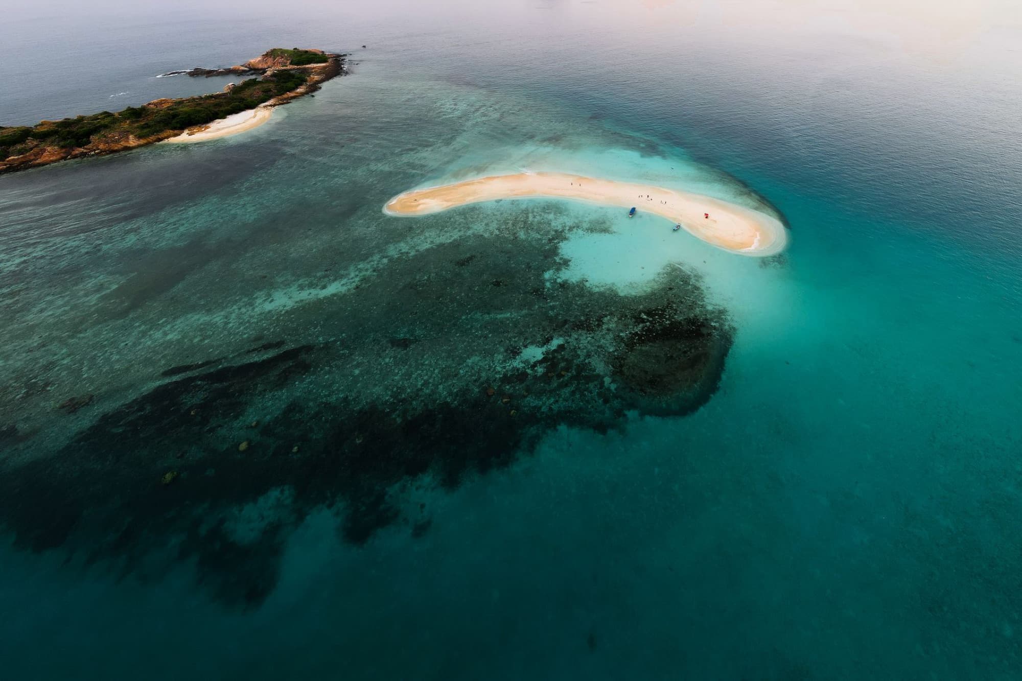 A stunning aerial shot of a secluded tropical island surrounded by turquoise waters, perfect for travel and nature enthusiasts.