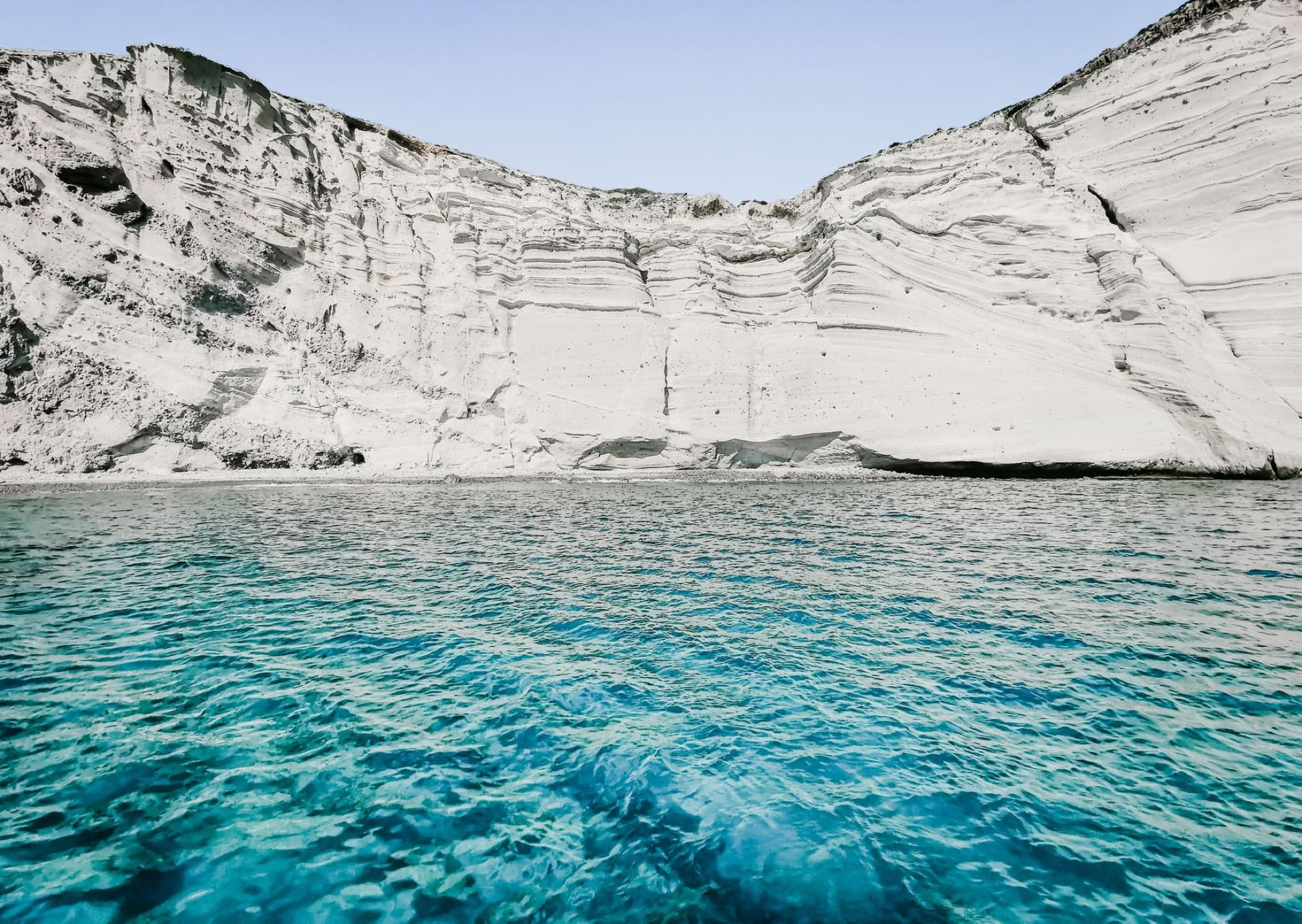 Scenic view of majestic eroded cliffs and turquoise sea in Antiparos, Greece.