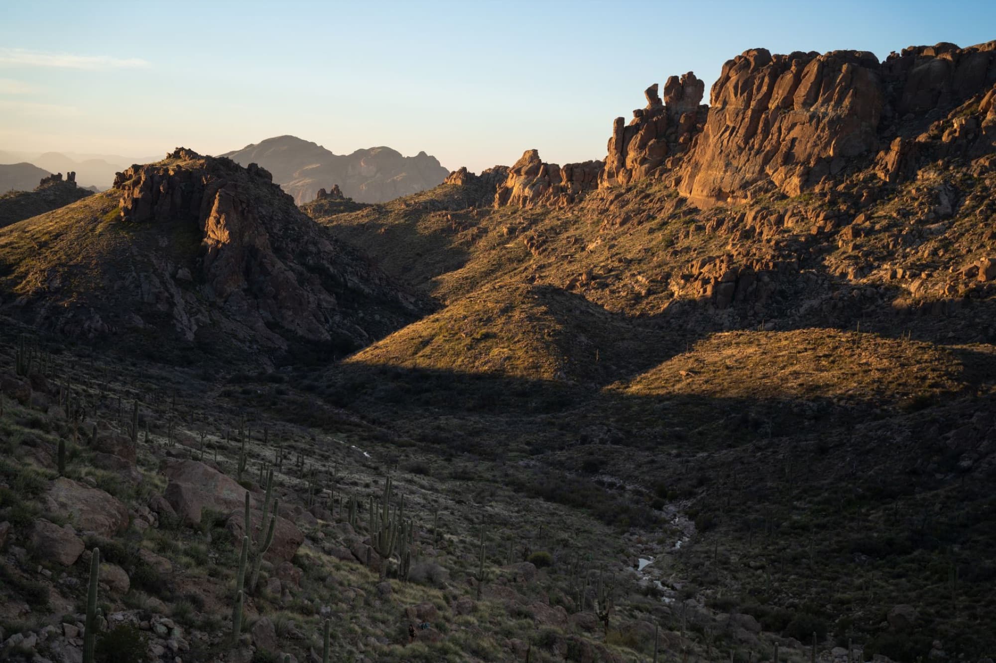 Breathtaking view of Superstition Mountains in Arizona during sunset, showcasing rugged peaks and desert landscape.