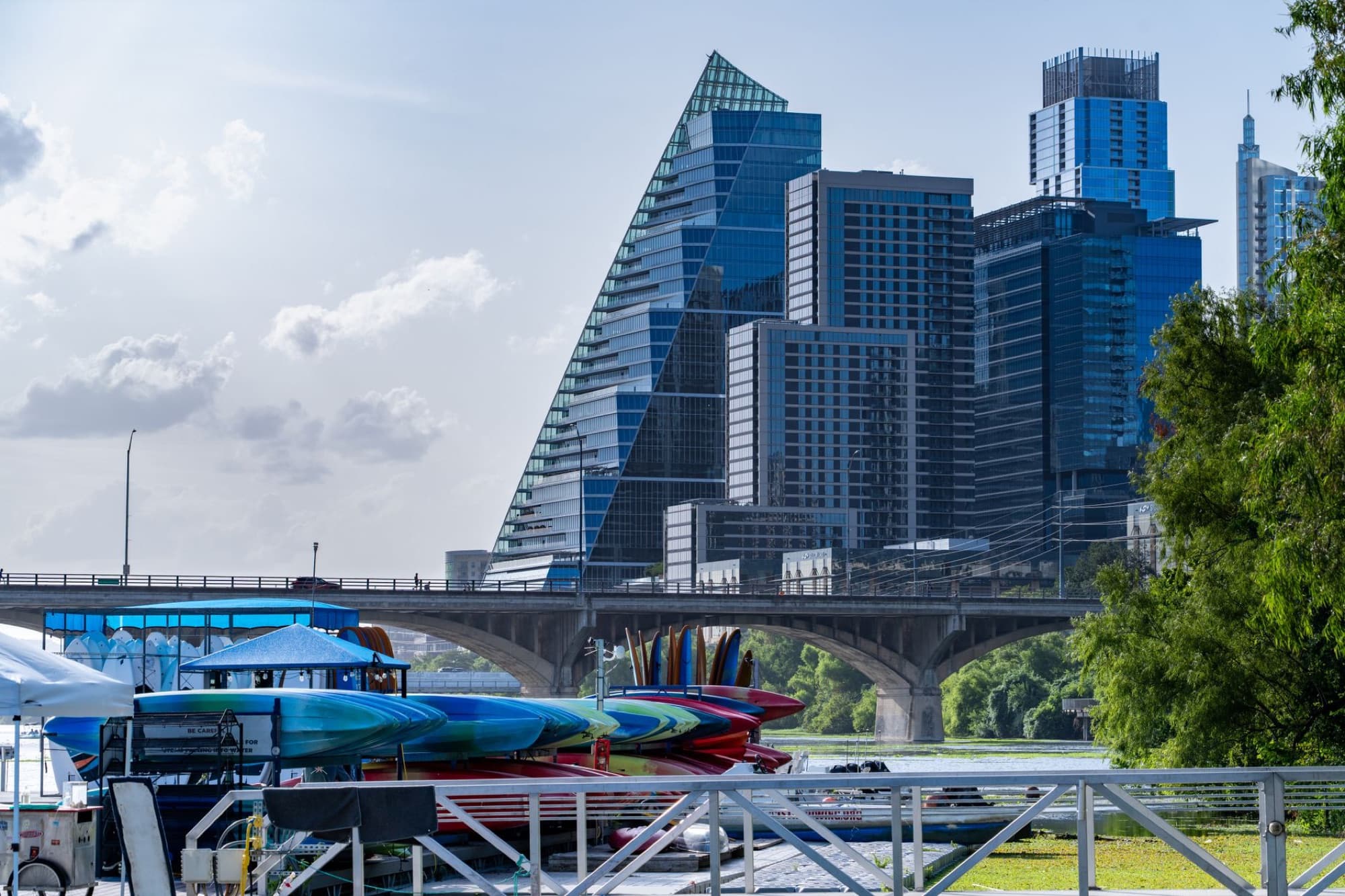 A scenic view of Austin's modern skyline with colorful kayaks along the riverfront.