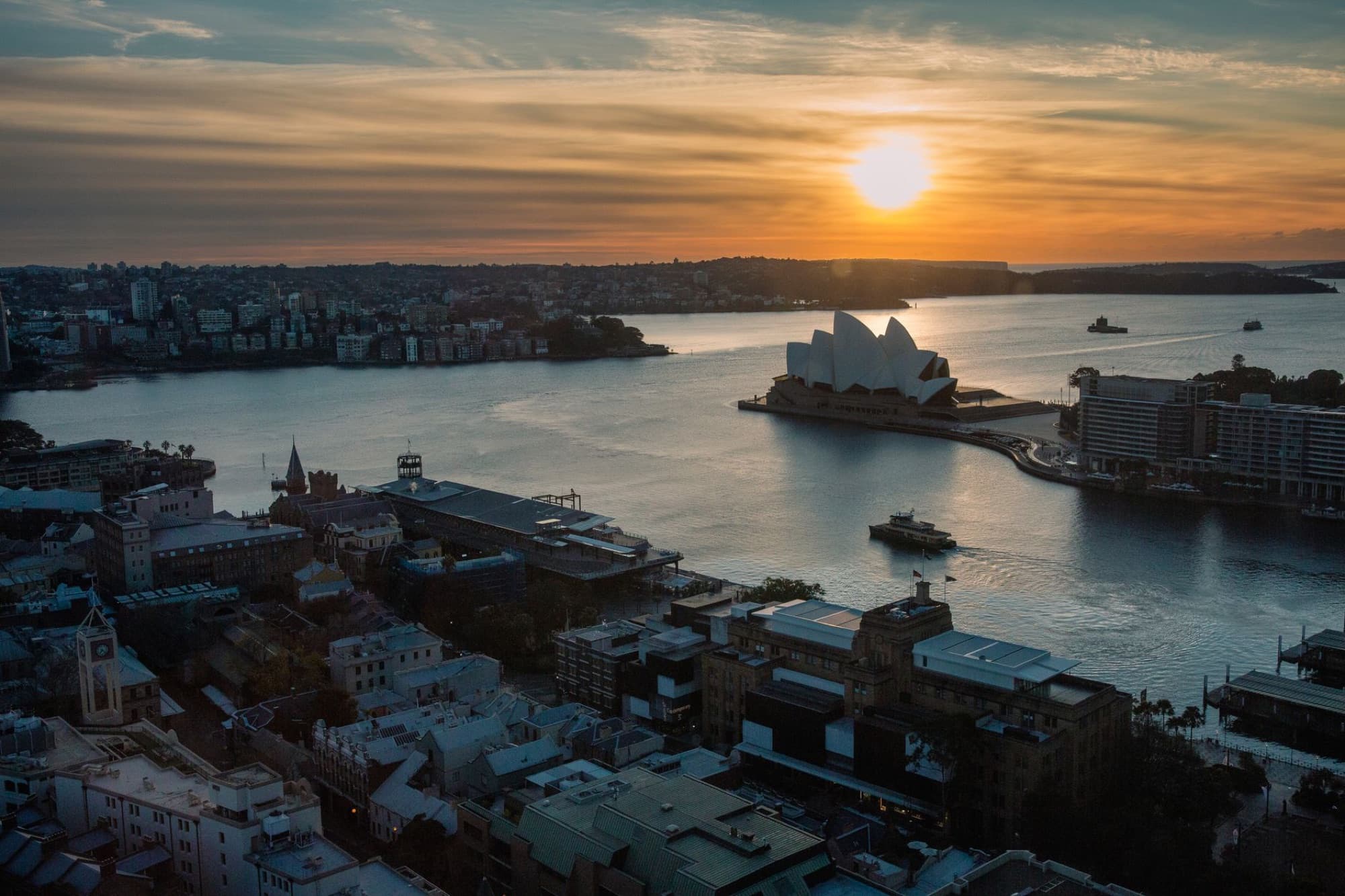 Aerial view of Sydney Opera House with sunset over the harbor skyline, New South Wales, Australia.