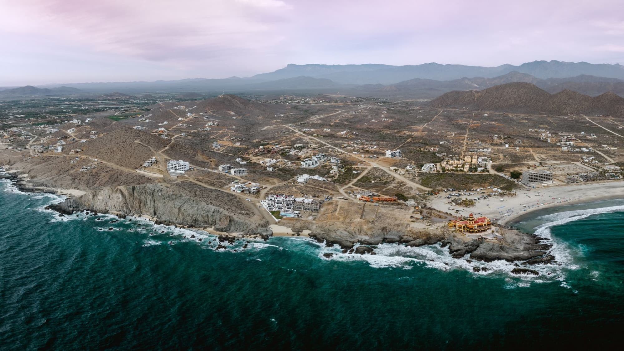 Stunning aerial view of Playa Los Cerritos beach and coastline in Baja California Sur, Mexico with waves and cliffs.