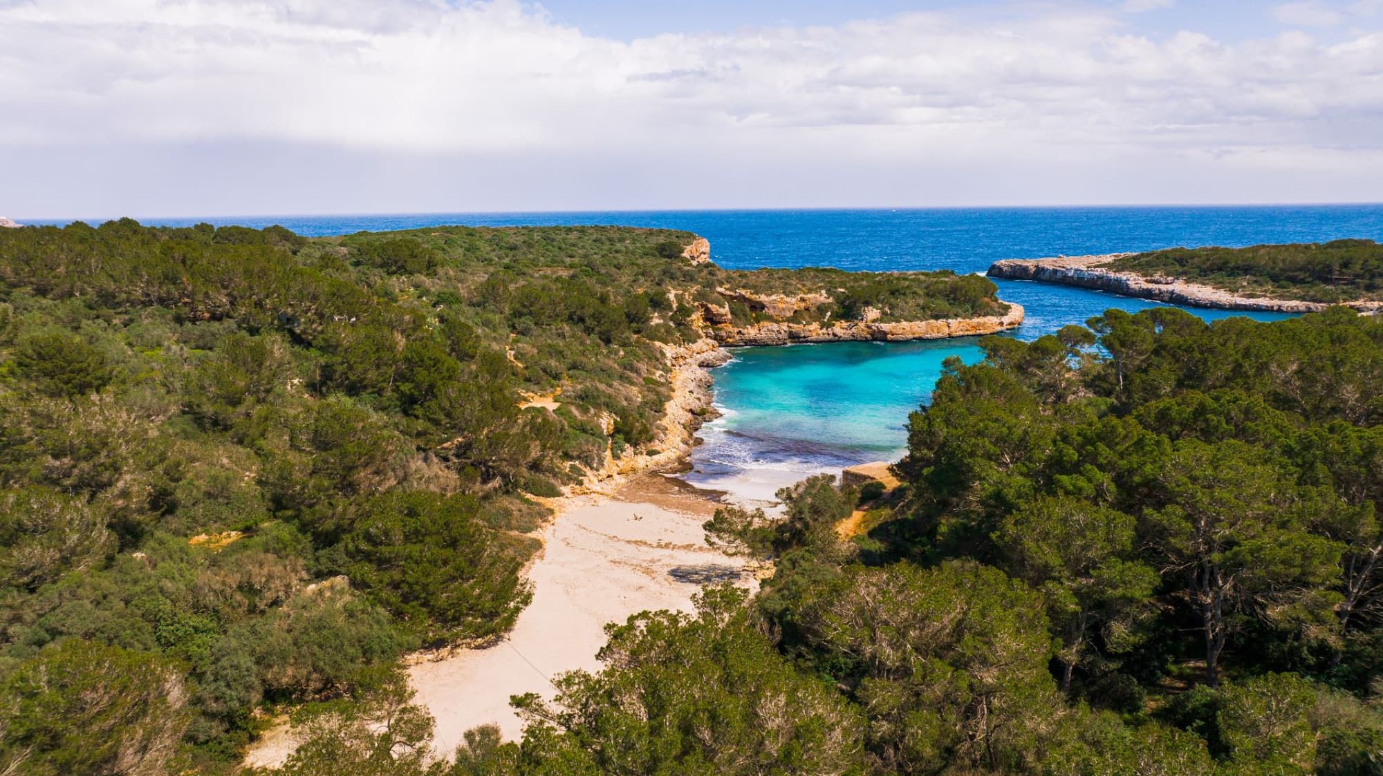 A stunning aerial view of a secluded beach cove in Mallorca, Balearic Islands, Spain.