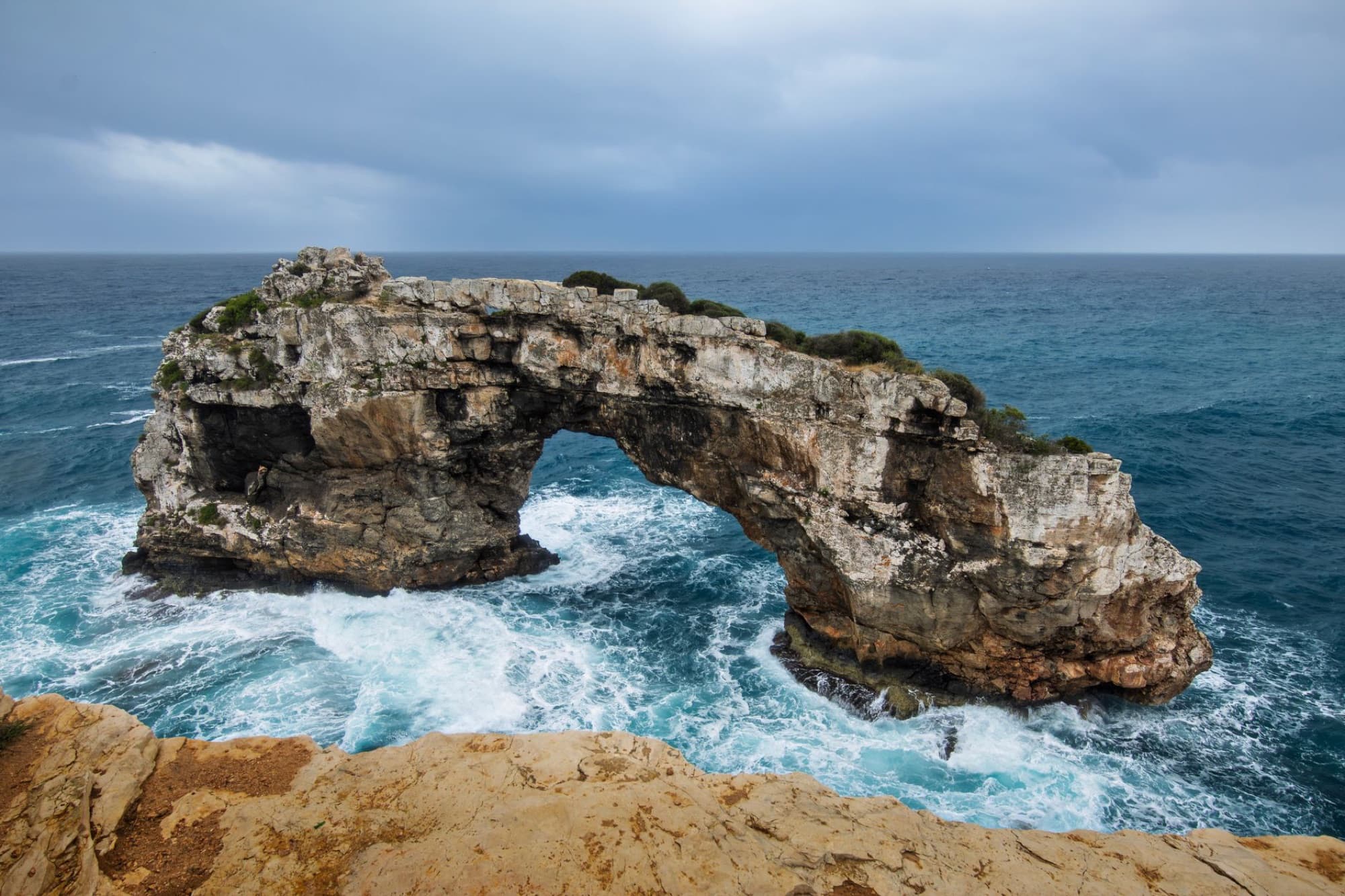 Spectacular rocky arch formation over the ocean waves at Cala Santanyí, Balearic Islands, Spain.