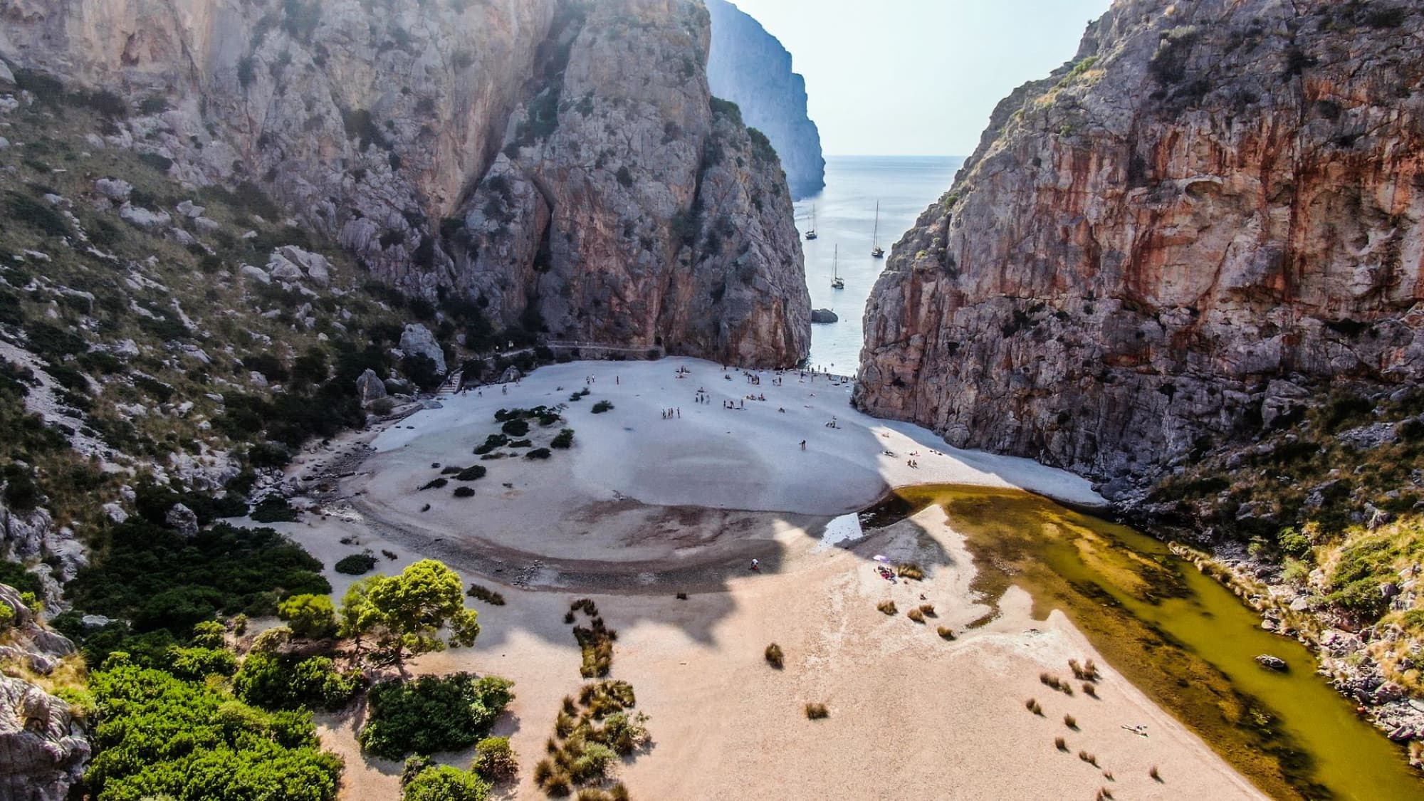 Scenic aerial view of Torrent de Pareis beach surrounded by cliffs in Mallorca, Spain.
