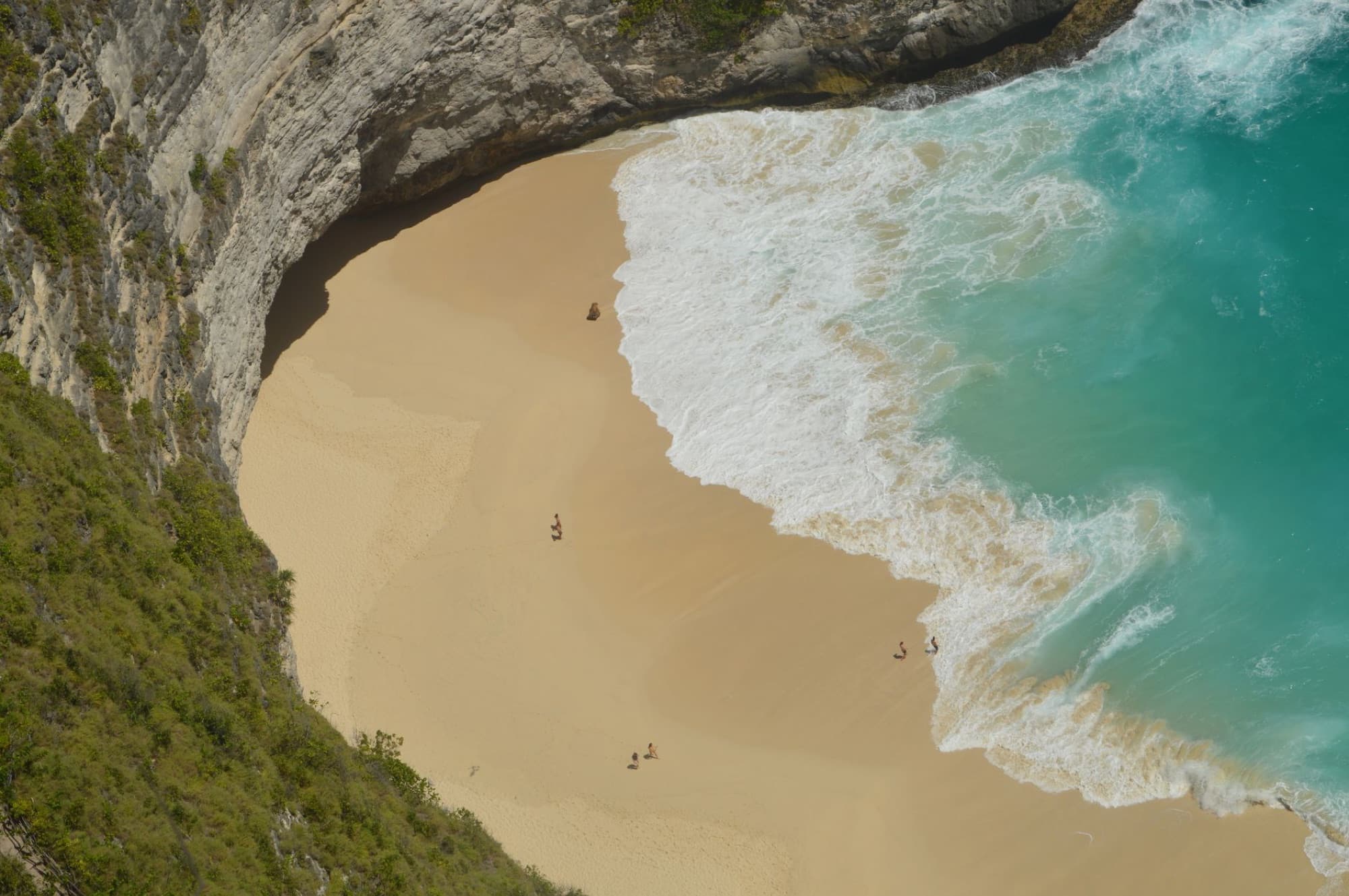 A breathtaking aerial view of a secluded beach in Bali, Indonesia with turquoise waters.