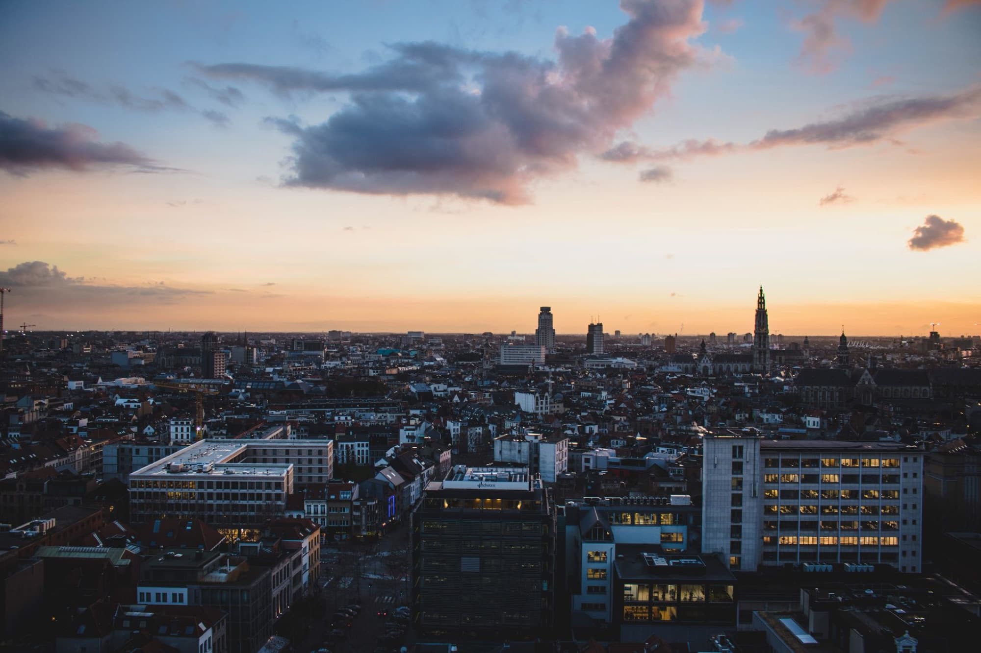 A stunning aerial view of Antwerp, Belgium, cityscape at dusk with vibrant sky colors.