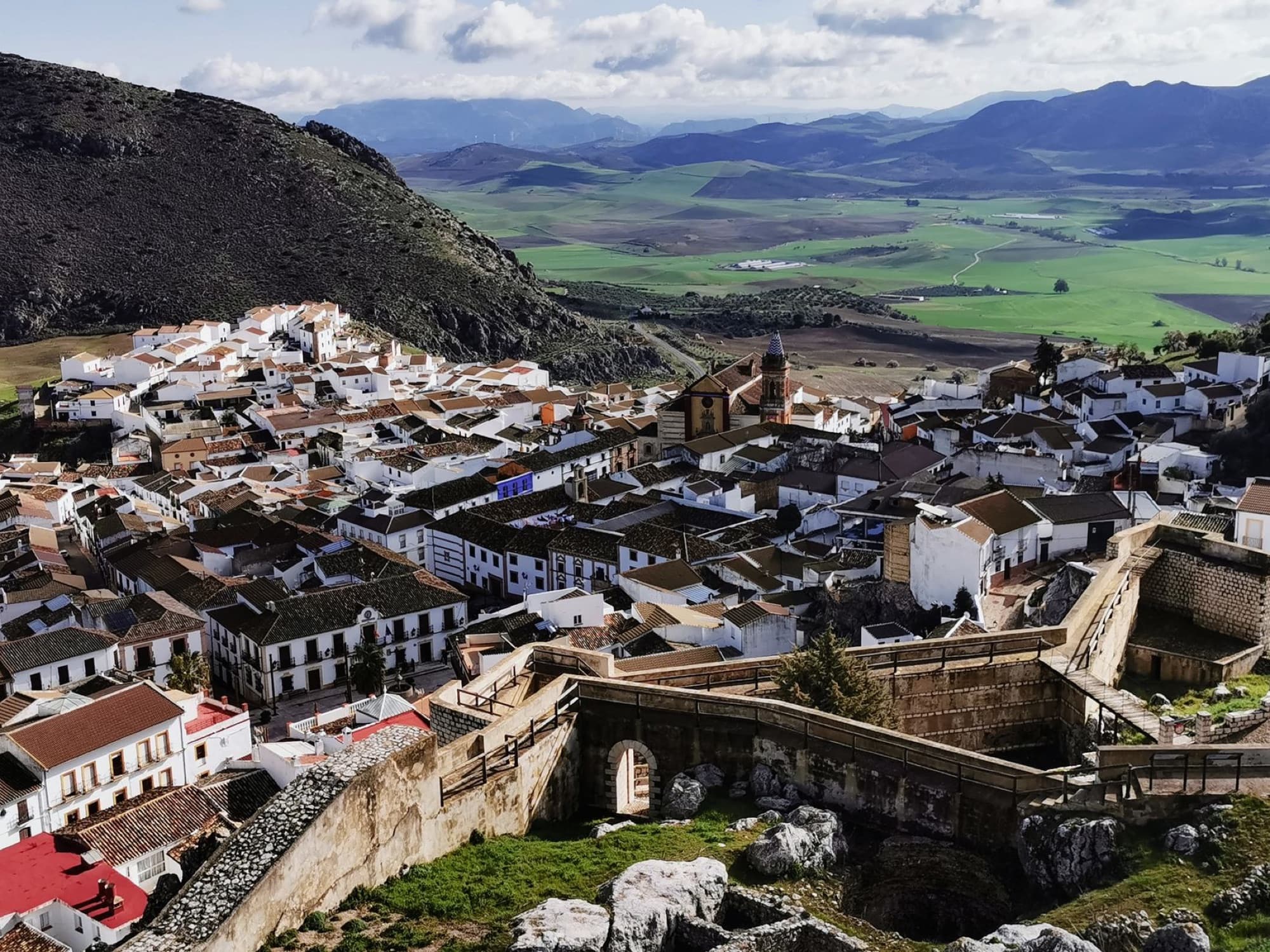 A breathtaking aerial view of a historic Spanish village with whitewashed buildings and scenic landscape.