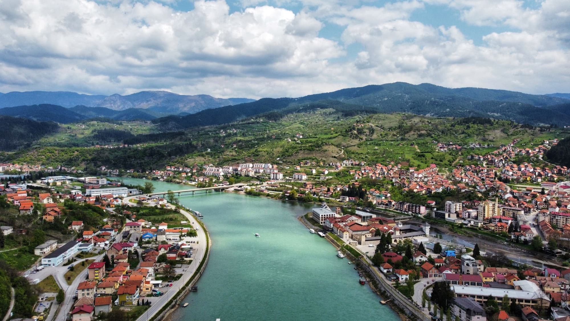 A stunning aerial view of Višegrad, Bosnia and Herzegovina, showcasing the Drina River and surrounding landscape.