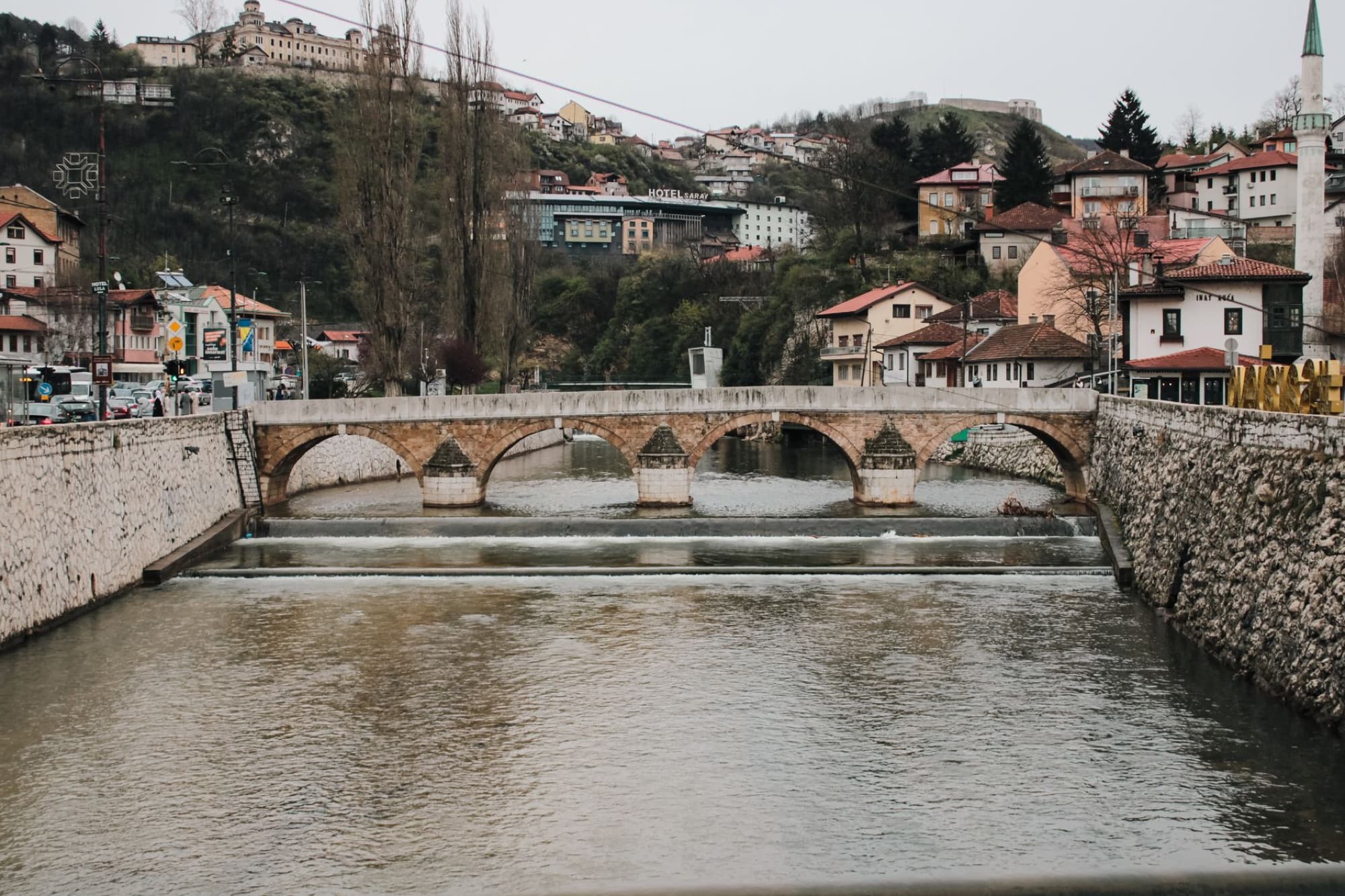 Scenic view of a historic stone bridge over the Miljacka River in Sarajevo, Bosnia and Herzegovina.