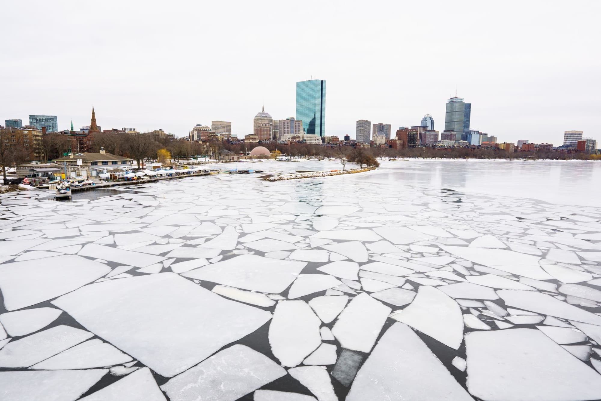 Aerial view of the icy Charles River with Boston's skyline in winter.
