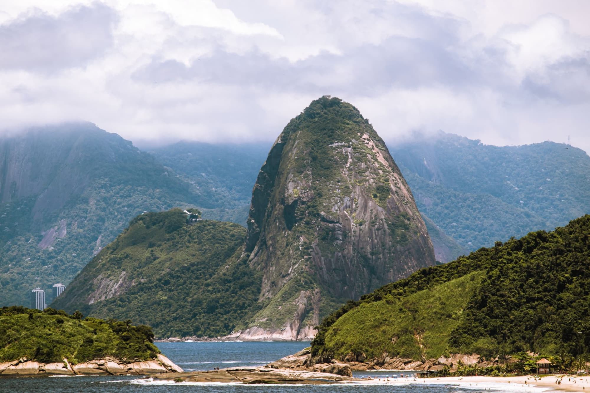 Breathtaking landscape of Sugarloaf Mountain shrouded in clouds, seen from Niterói, Brazil.