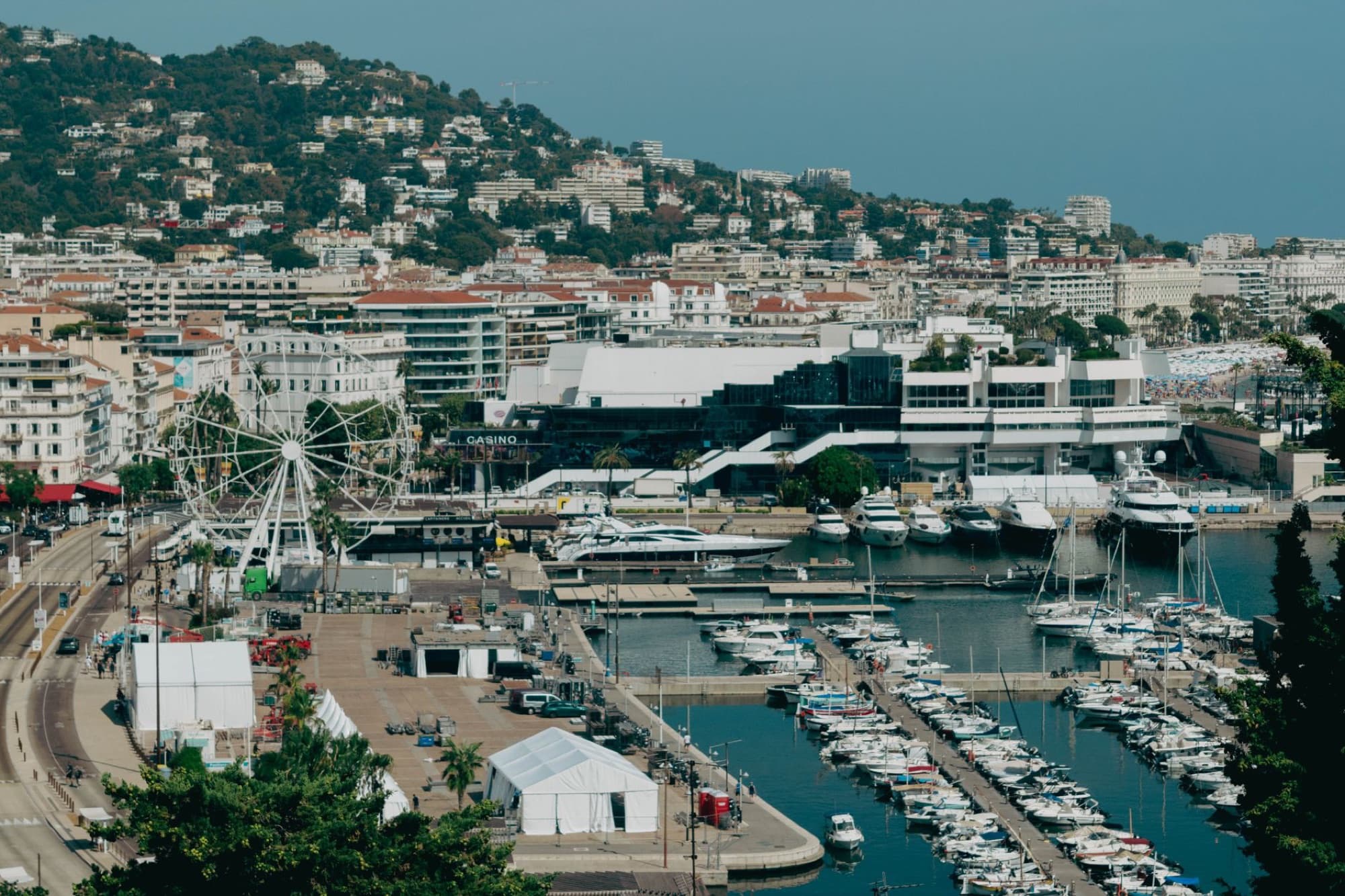 Scenic aerial shot of Cannes harbor with yachts and cityscape, capturing the essence of the French Riviera.