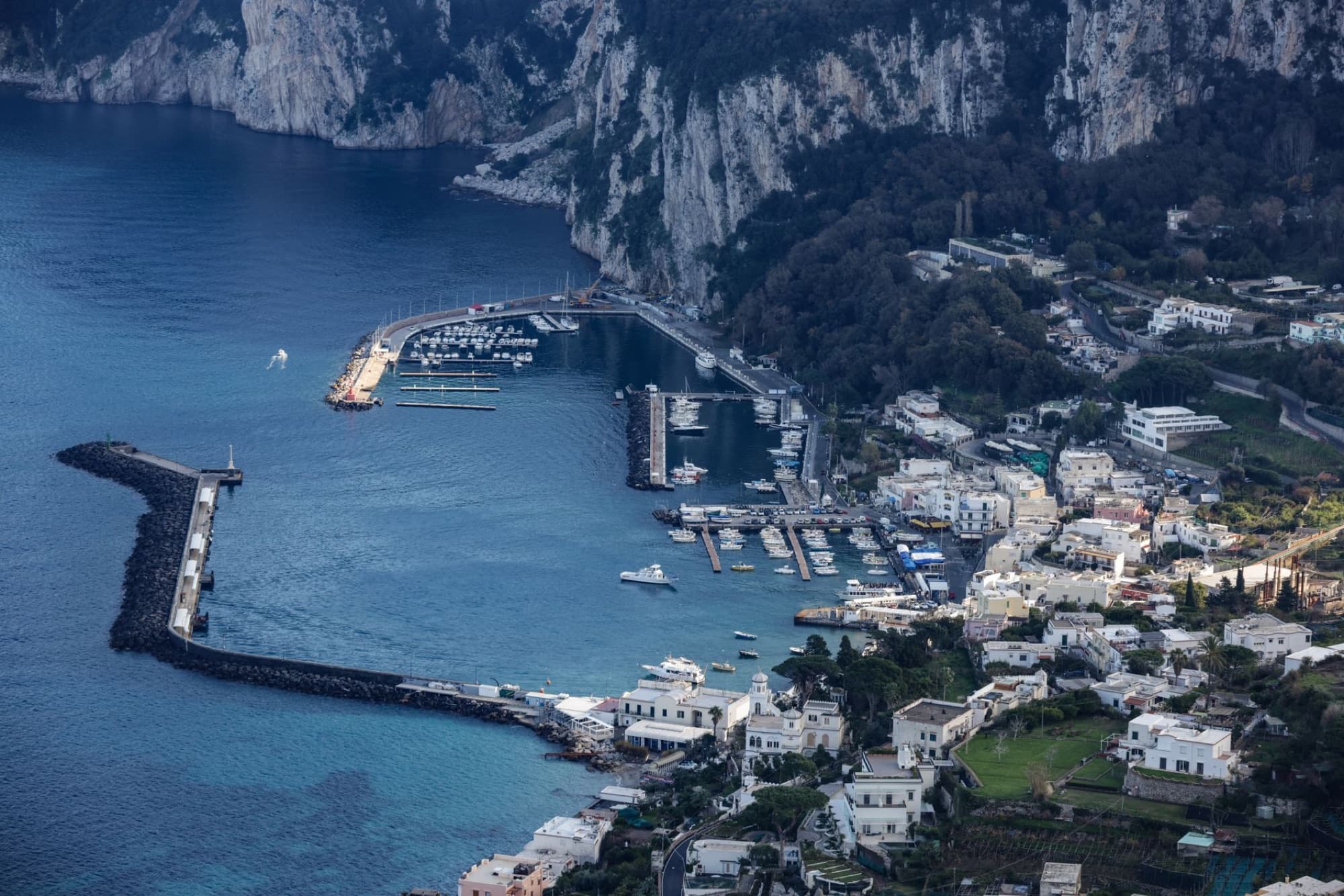 Scenic aerial view of the marina and coastline in Capri, Italy, showcasing Mediterranean beauty.