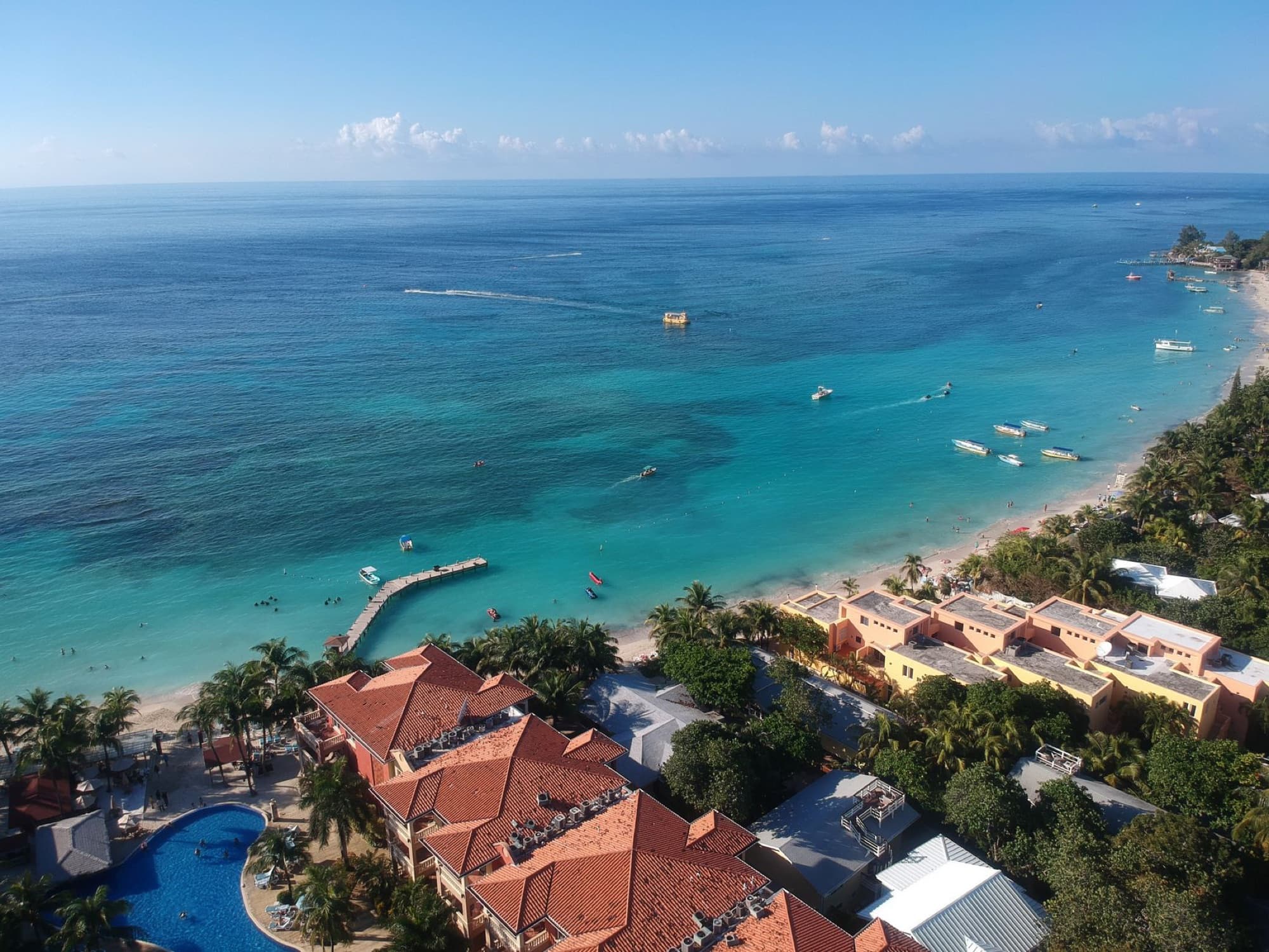 Aerial view of West Bay Beach in Honduras featuring turquoise waters, sandy shores, and lush greenery.