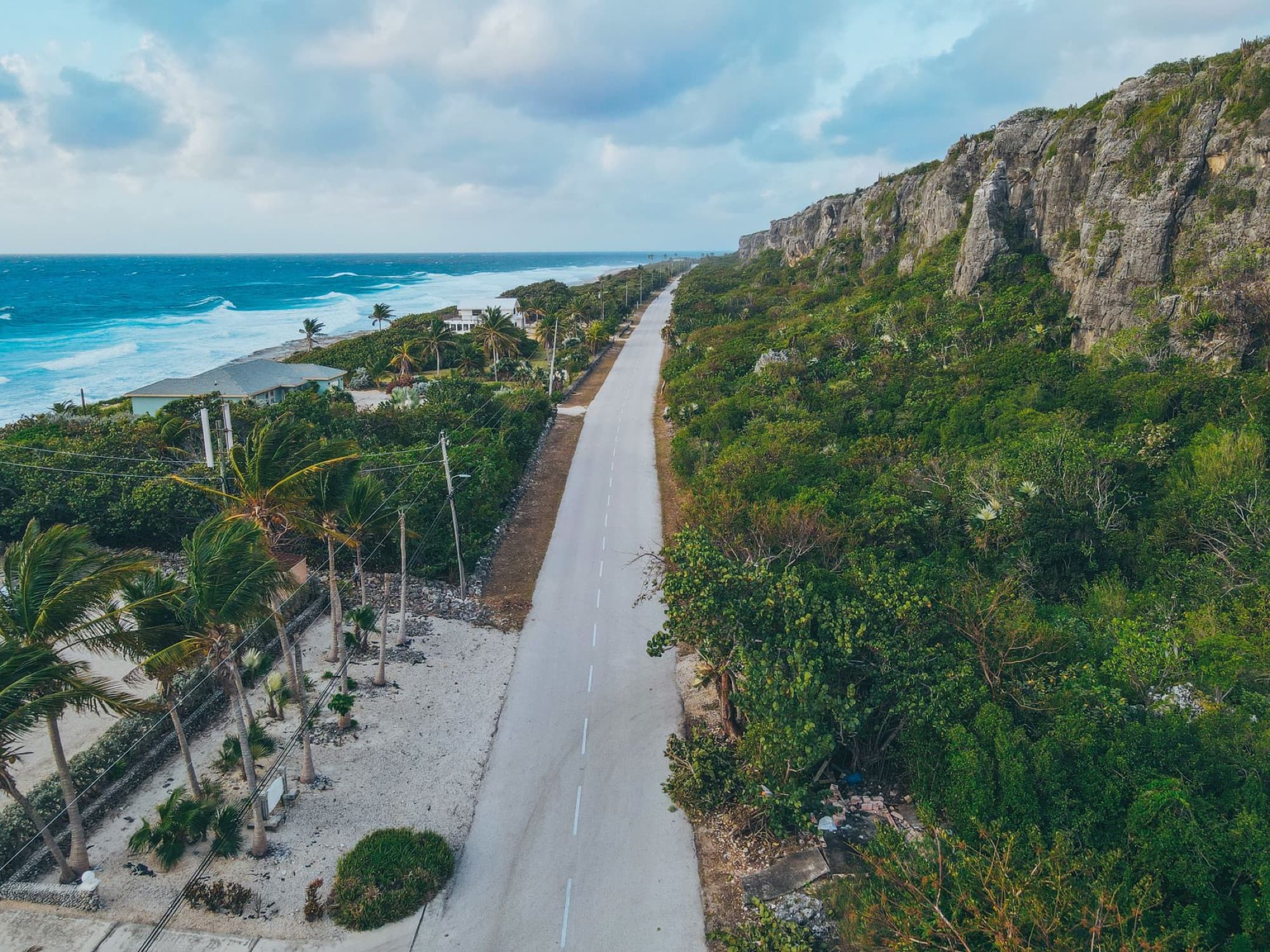 Aerial view showcasing the stunning coastline and road beside cliffs in Cayman Islands.