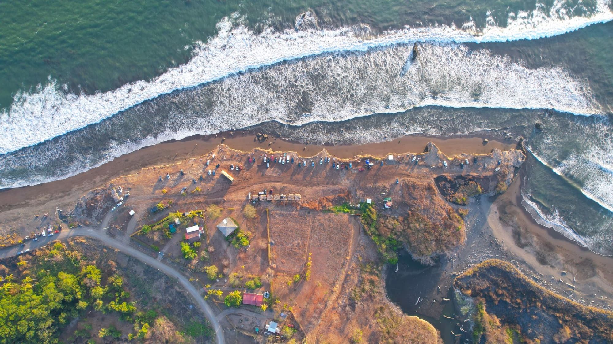 A breathtaking aerial view of Bajamar's coastline in Costa Rica, featuring waves crashing on the shore.