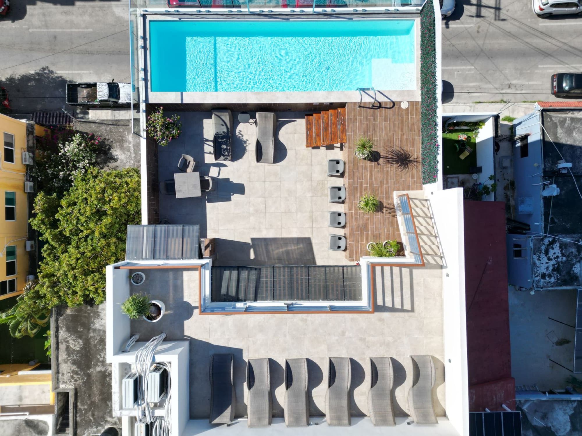 Drone shot of a luxury rooftop terrace with a pool in Playa del Carmen, showcasing modern architecture.