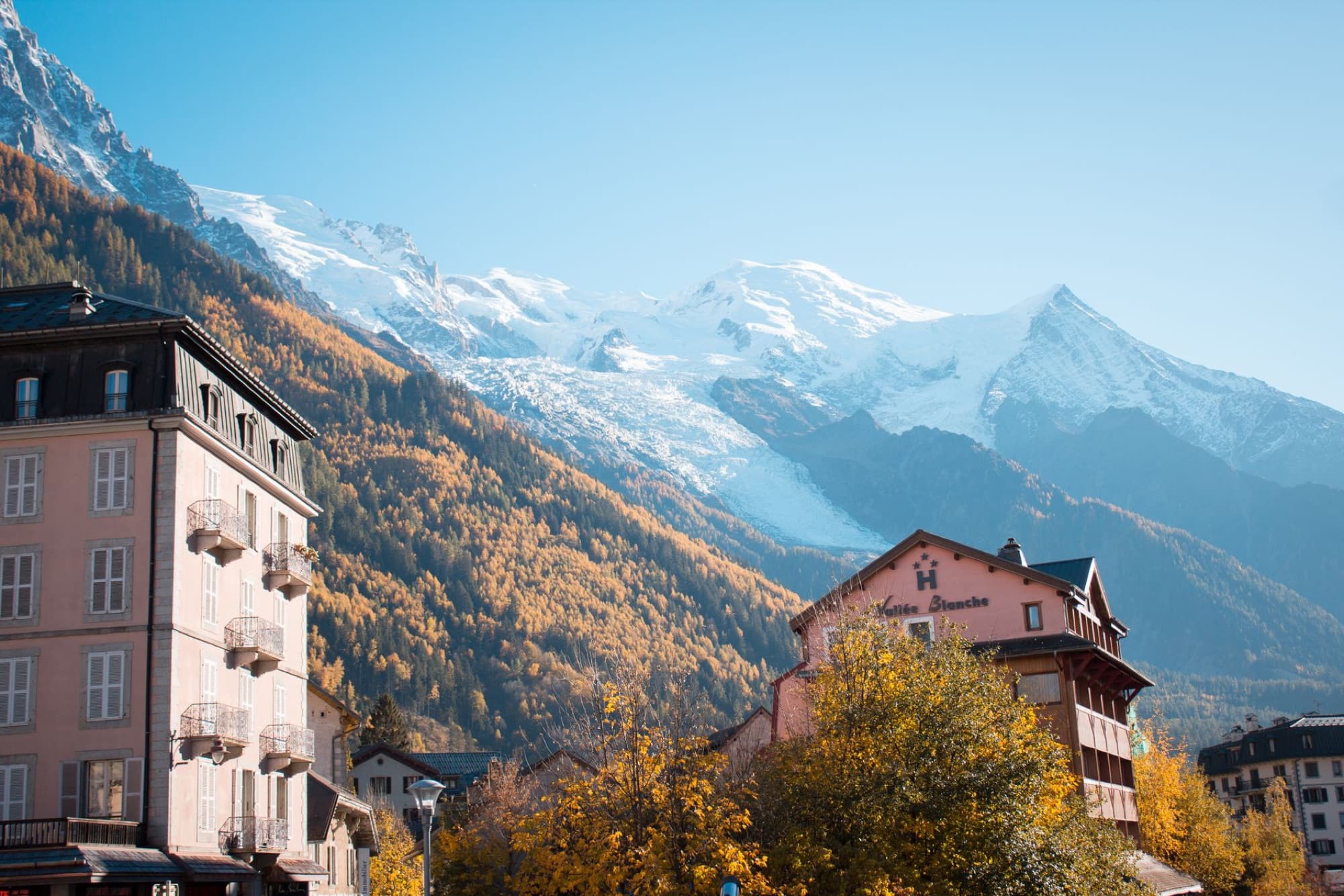 Scenic view of Chamonix with colorful autumn trees and snowcapped mountains in the background.