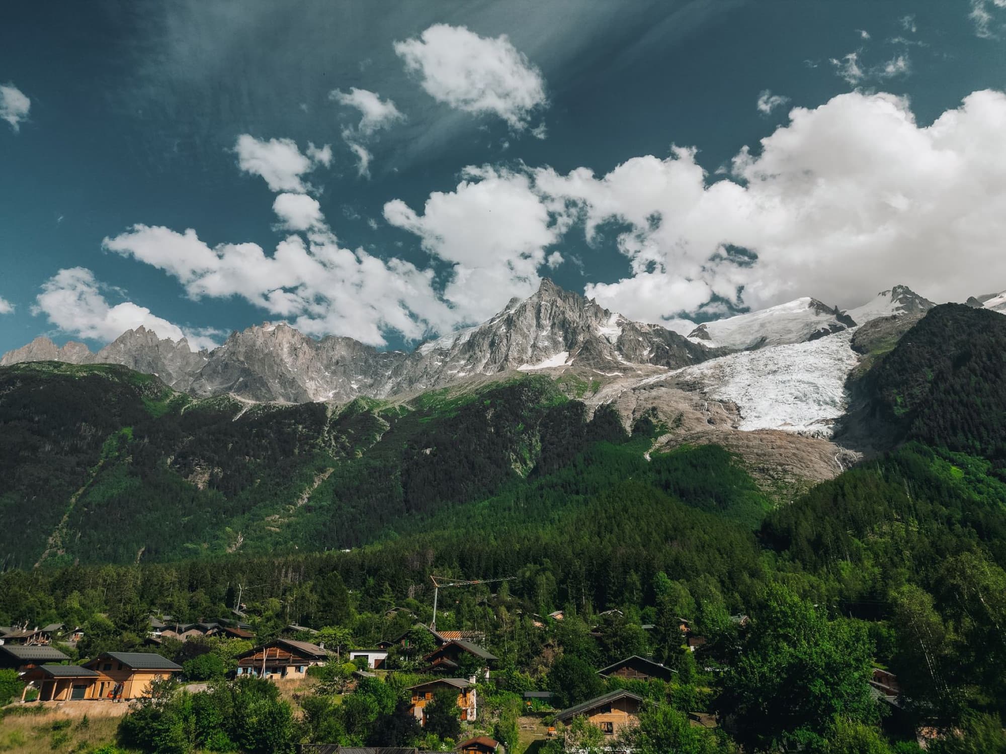 Scenic view of Chamonix-Mont-Blanc village against the majestic Alps under a vibrant sky.