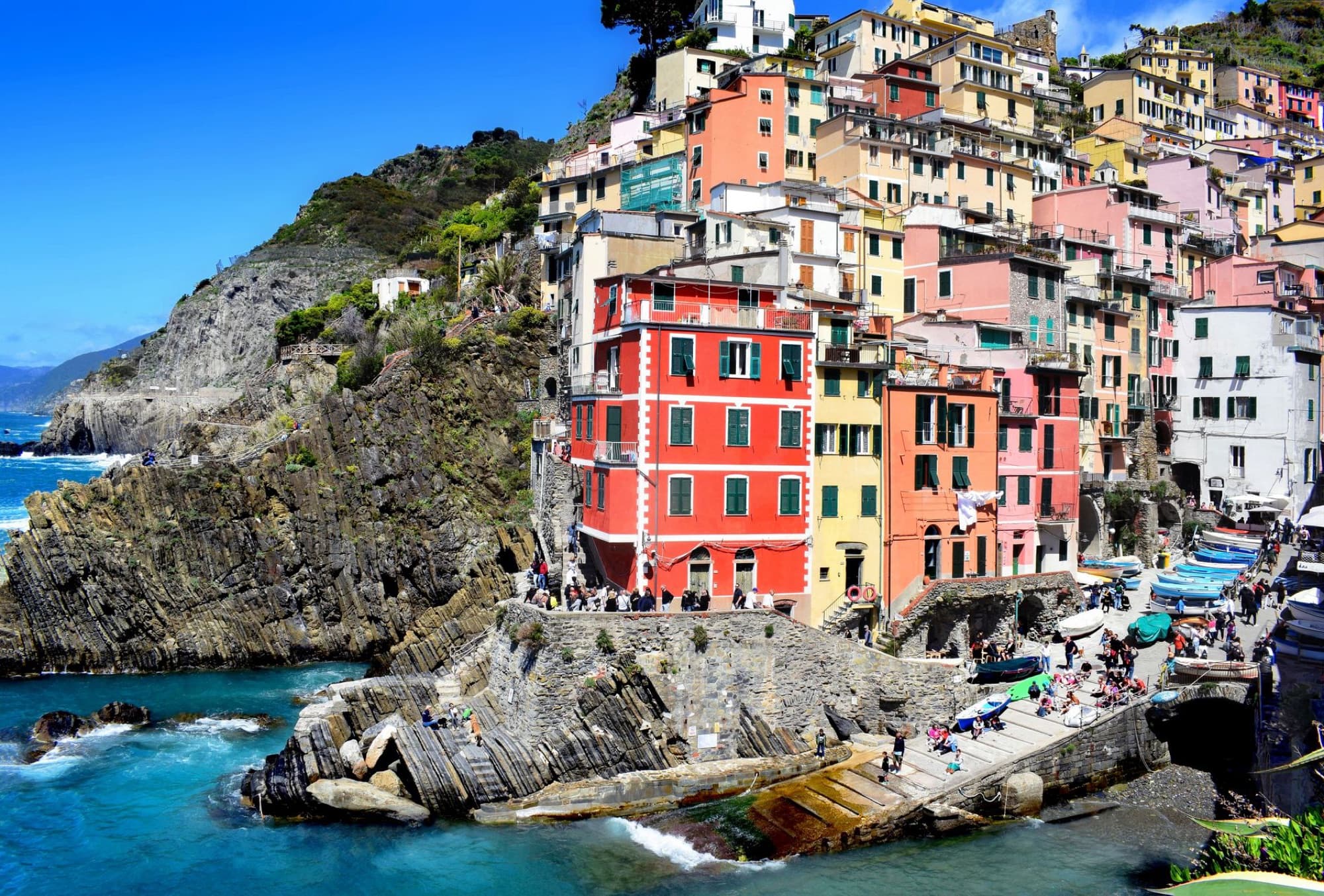 Vibrant buildings perched on cliffs by the sea in Riomaggiore, Italy's scenic Cinque Terre.