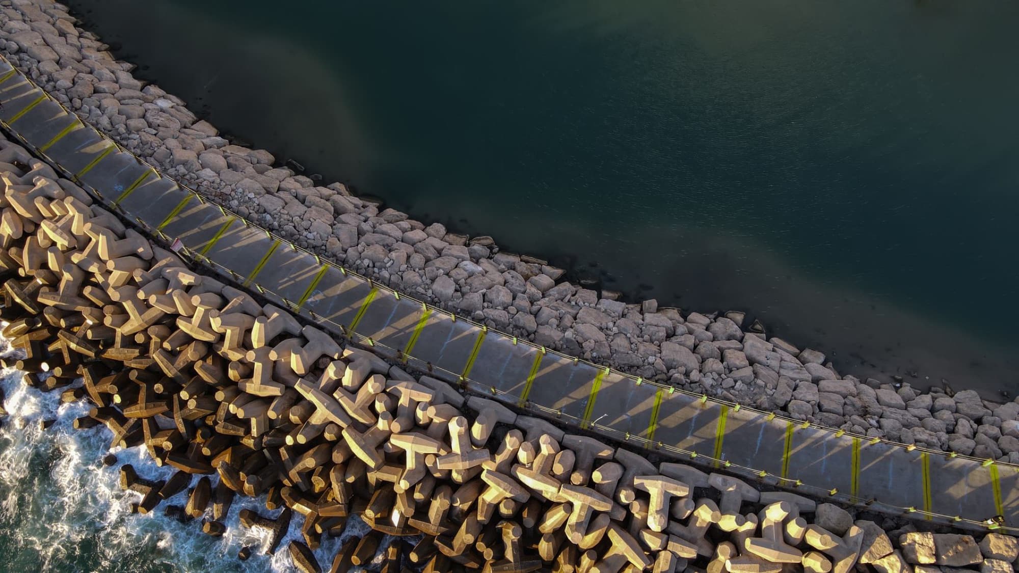Aerial view of a breakwater with calm coastal waters in Israel.