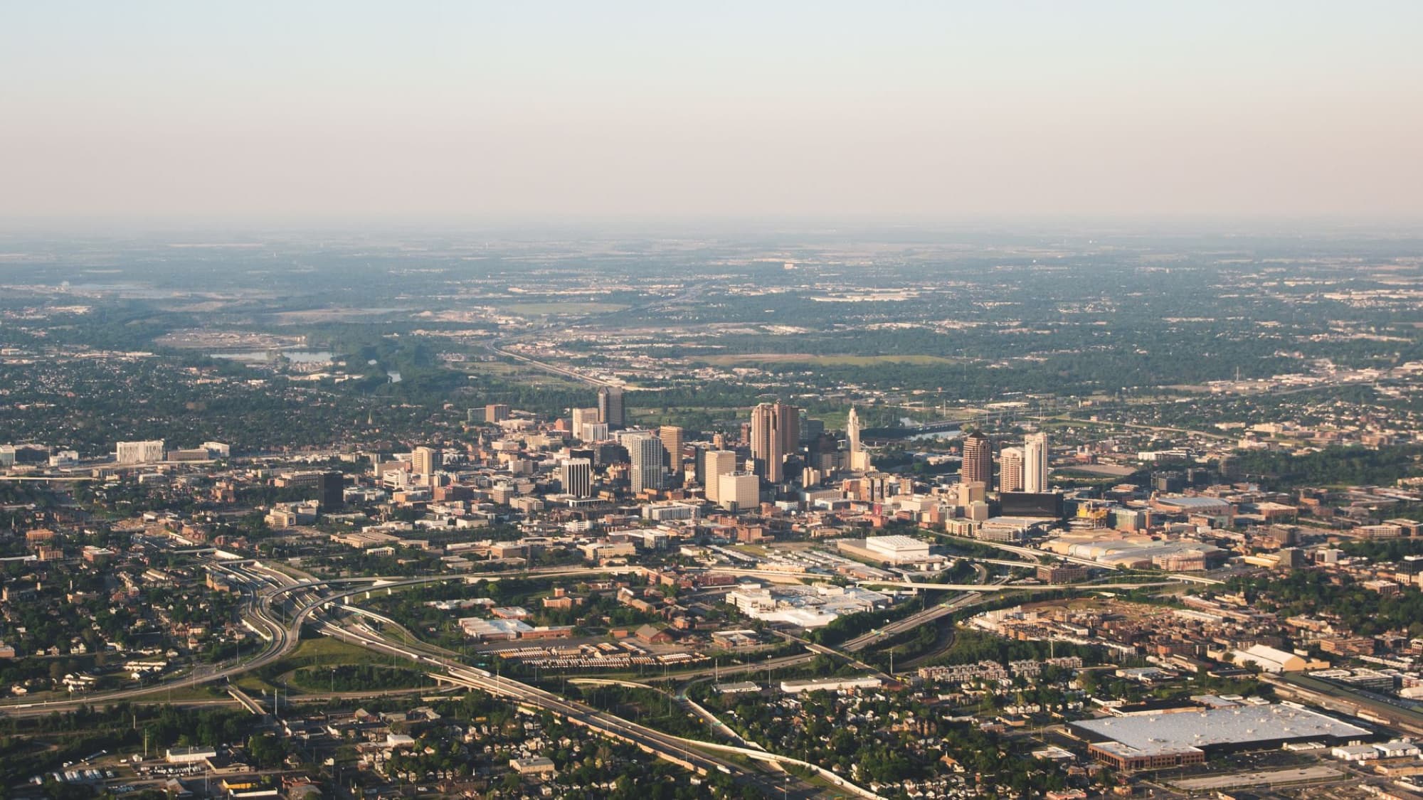Aerial photograph showcasing the sprawling cityscape of Columbus, Ohio during the day.