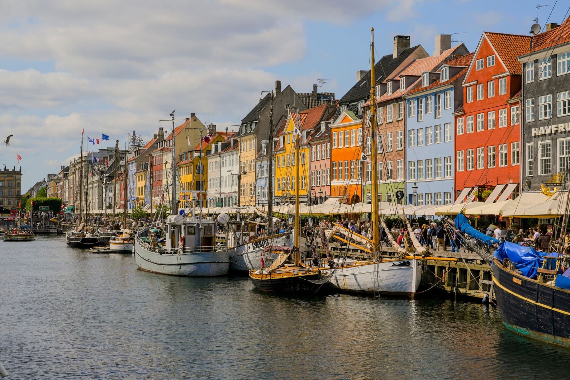 Scenic view of Nyhavn harbor with colorful buildings and boats in Copenhagen, Denmark.