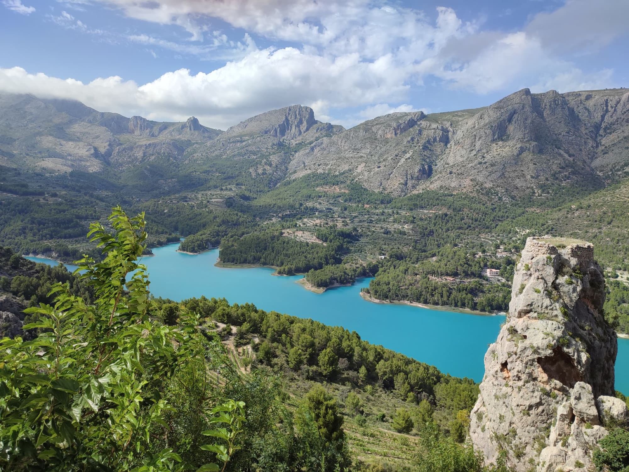 Stunning aerial photo showcasing Guadalest Valley's turquoise lake surrounded by rugged mountains.