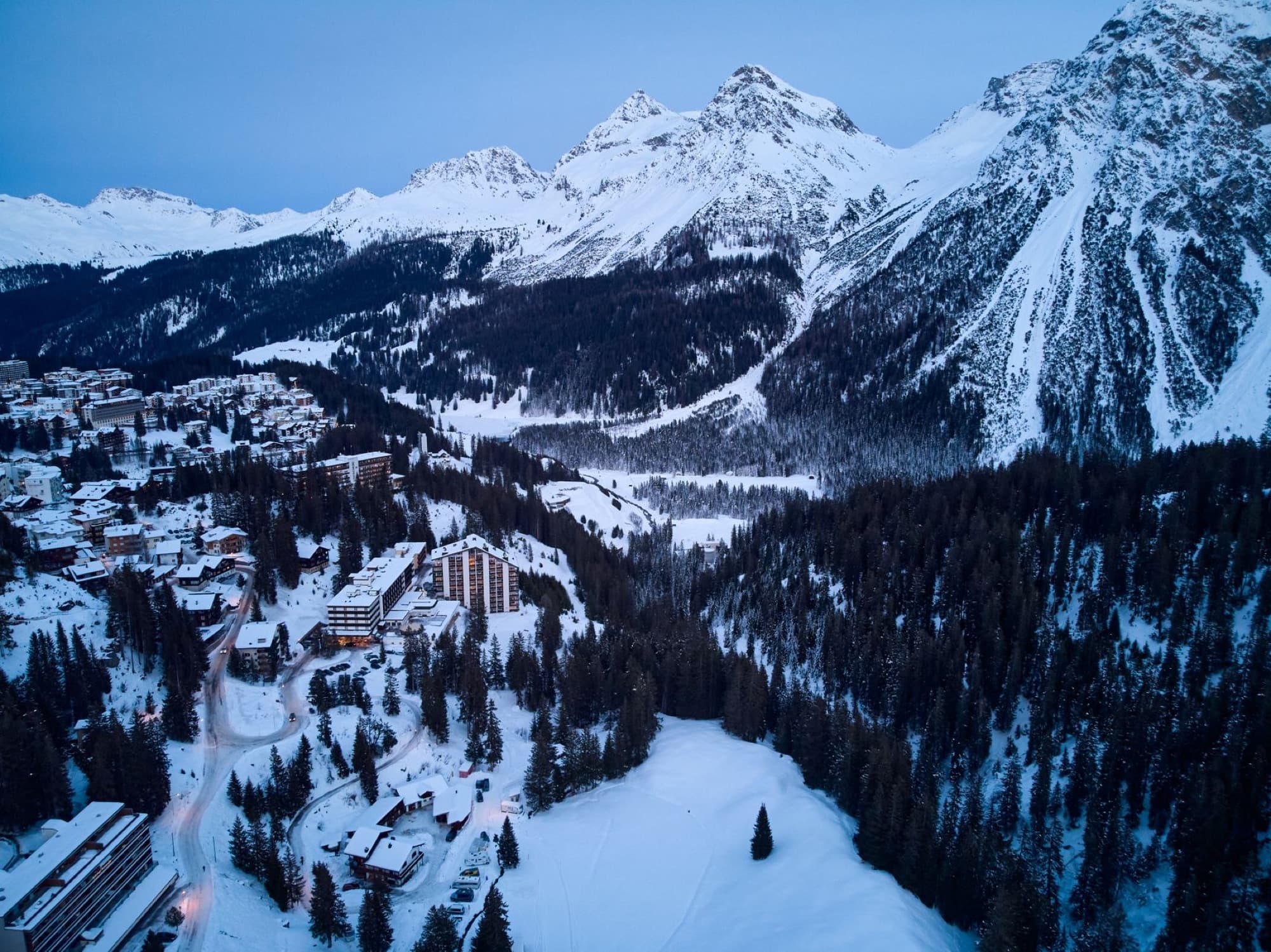 Aerial panorama of Arosa, Switzerland, showcasing snow-covered mountains and winter landscapes.