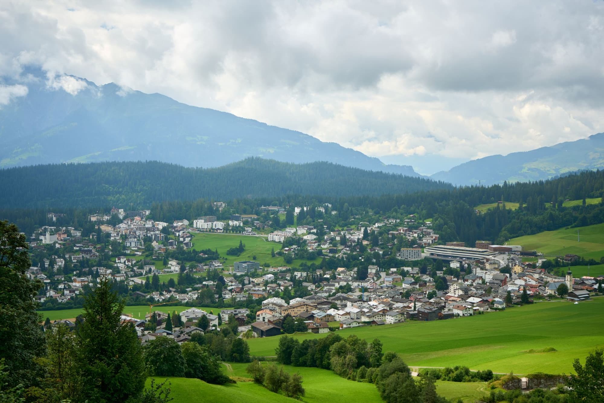 Picturesque aerial landscape of an Italian village surrounded by lush green fields and mountains.