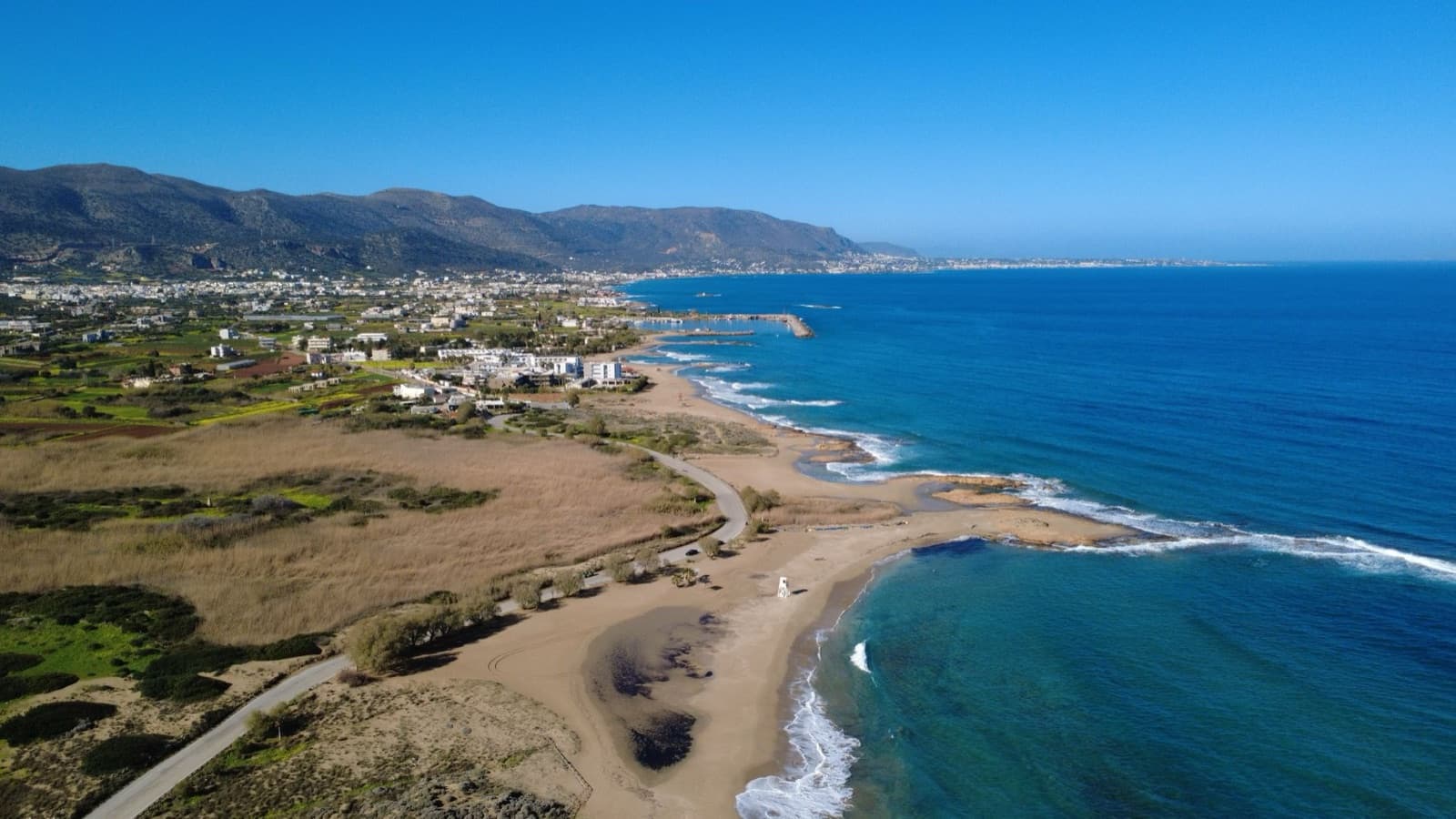 Stunning aerial view of Malia Beach with turquoise waters and scenic landscape in Crete, Greece.