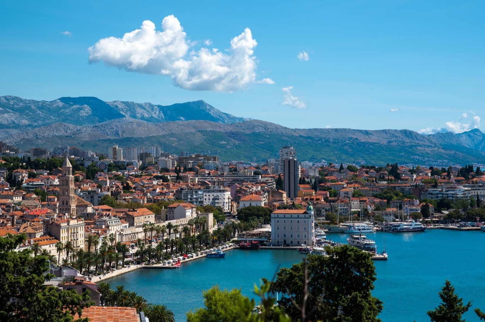 Vibrant aerial view of Split, Croatia, showcasing the coastline, harbor, and surrounding mountains.