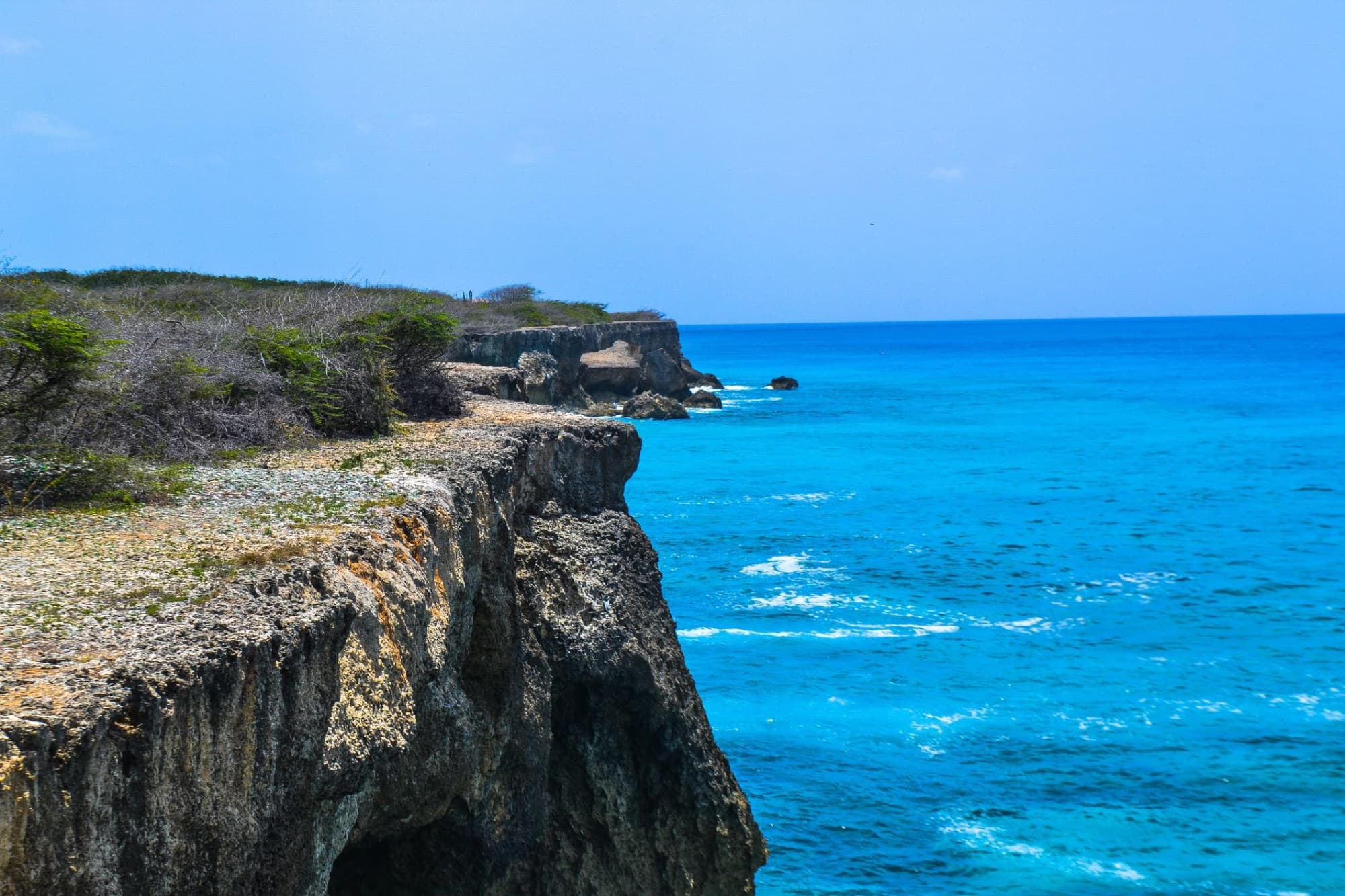 Experience the breathtaking cliffs and vibrant blue waters of Curaçao's Caribbean coast. Ideal for travel and nature enthusiasts.