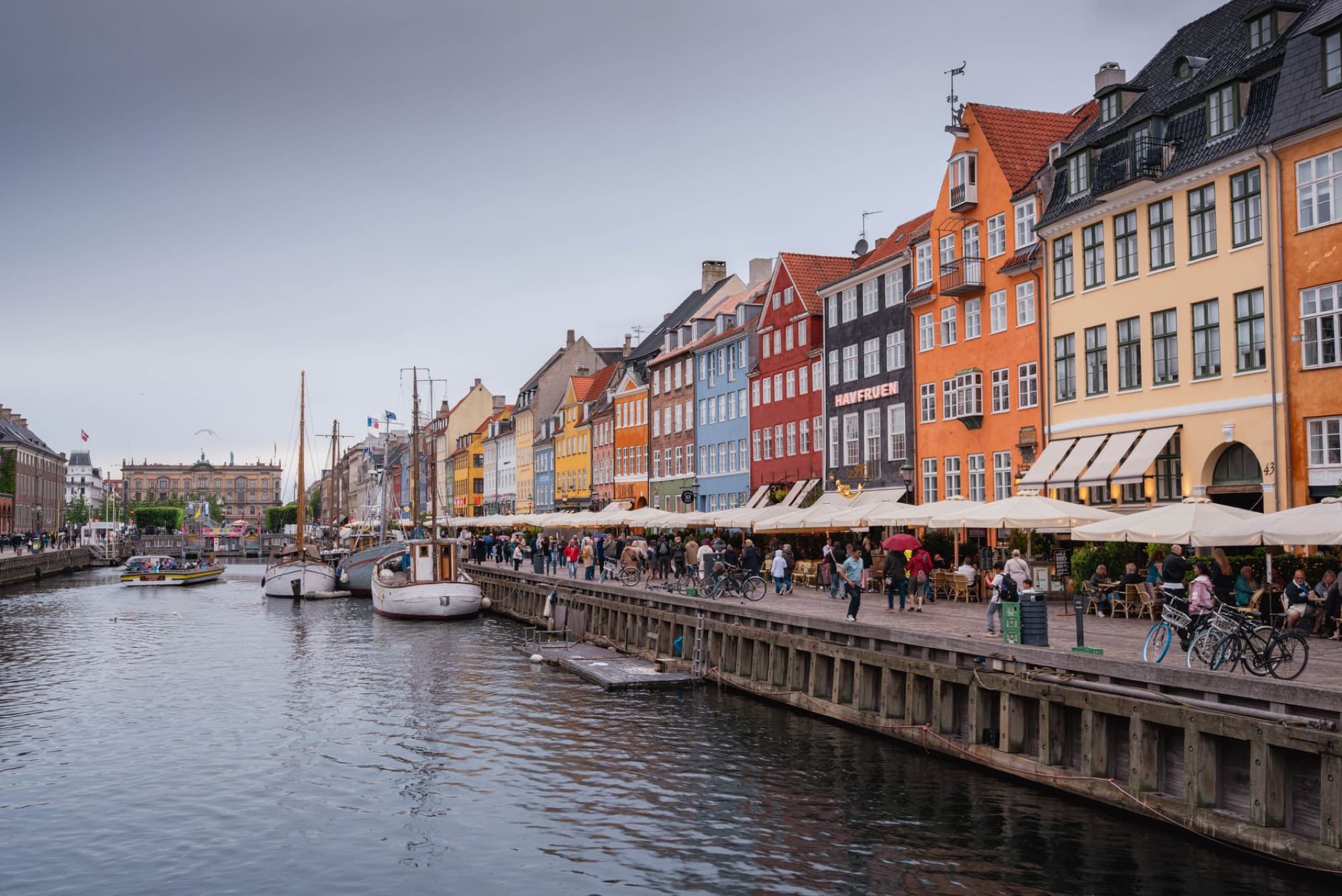 Scenic view of Nyhavn canal with vibrant buildings and boats in Copenhagen, Denmark.