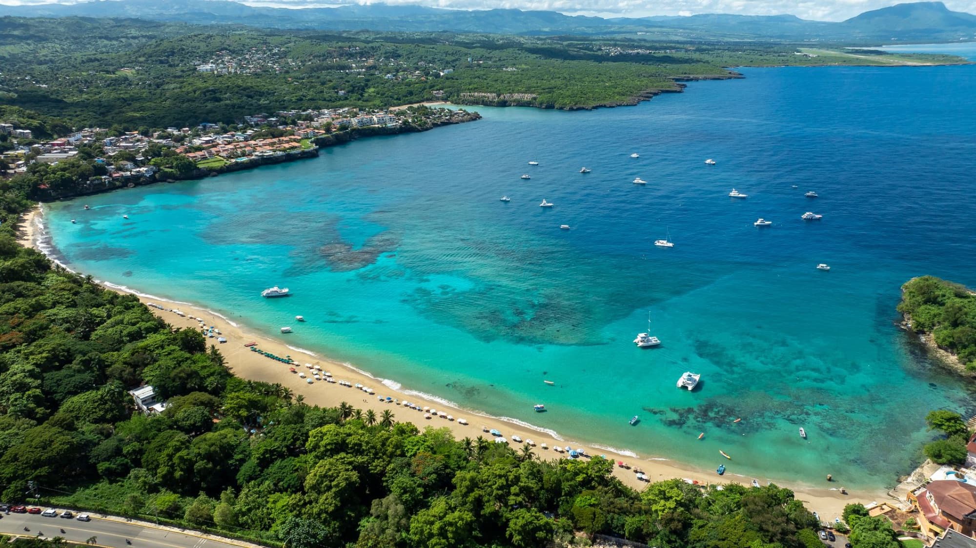 Stunning aerial photograph of Sosúa Beach's turquoise waters and vibrant coastline in the Dominican Republic.