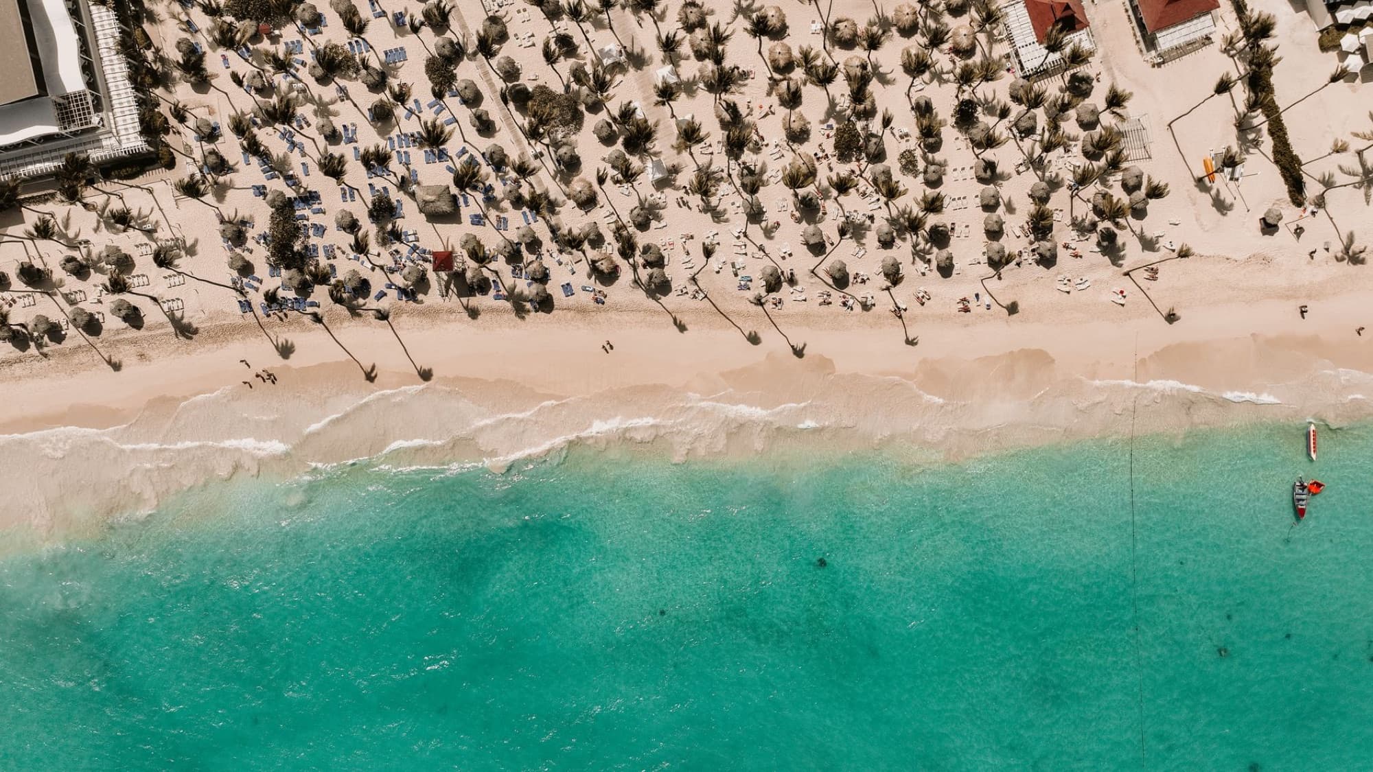 Stunning aerial view of a tropical beach in the Dominican Republic with white sand and turquoise water.
