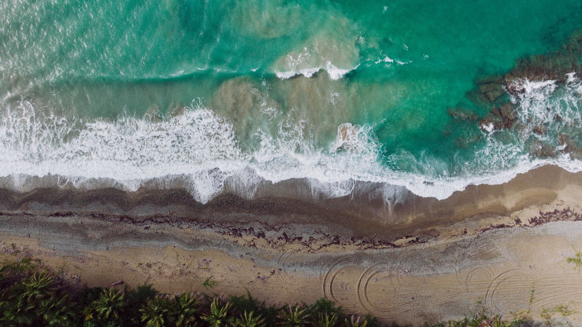 A breathtaking aerial view capturing the vibrant shoreline and waves of Patillas Beach, Puerto Rico.