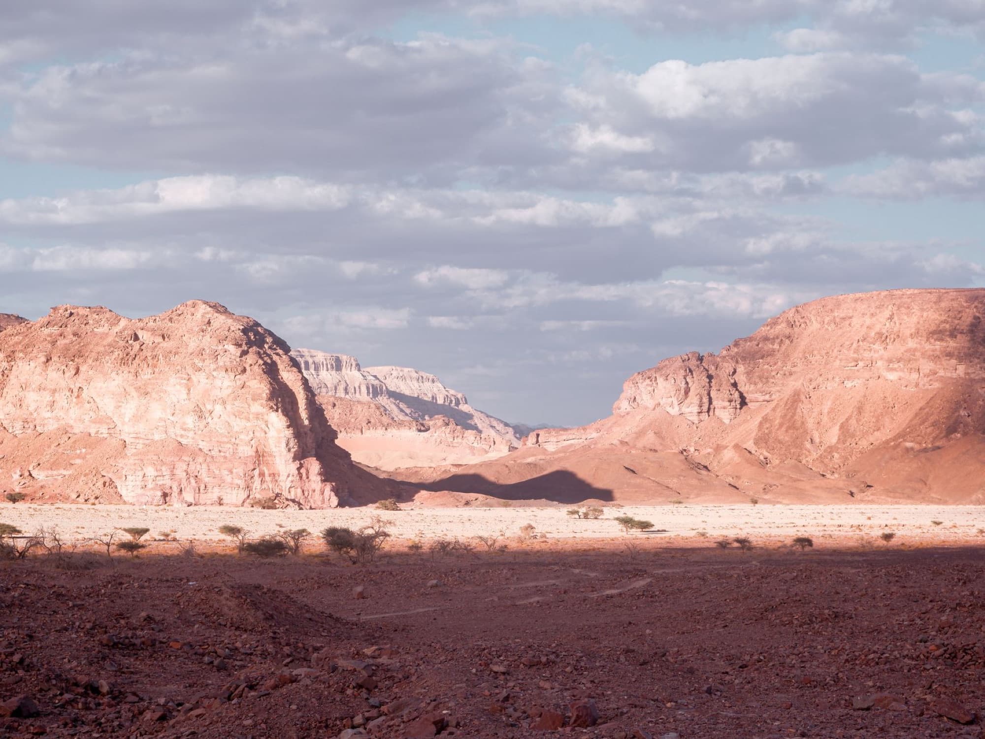 Beautiful arid landscape in Eilat with rocky mountains under a cloudy sky.