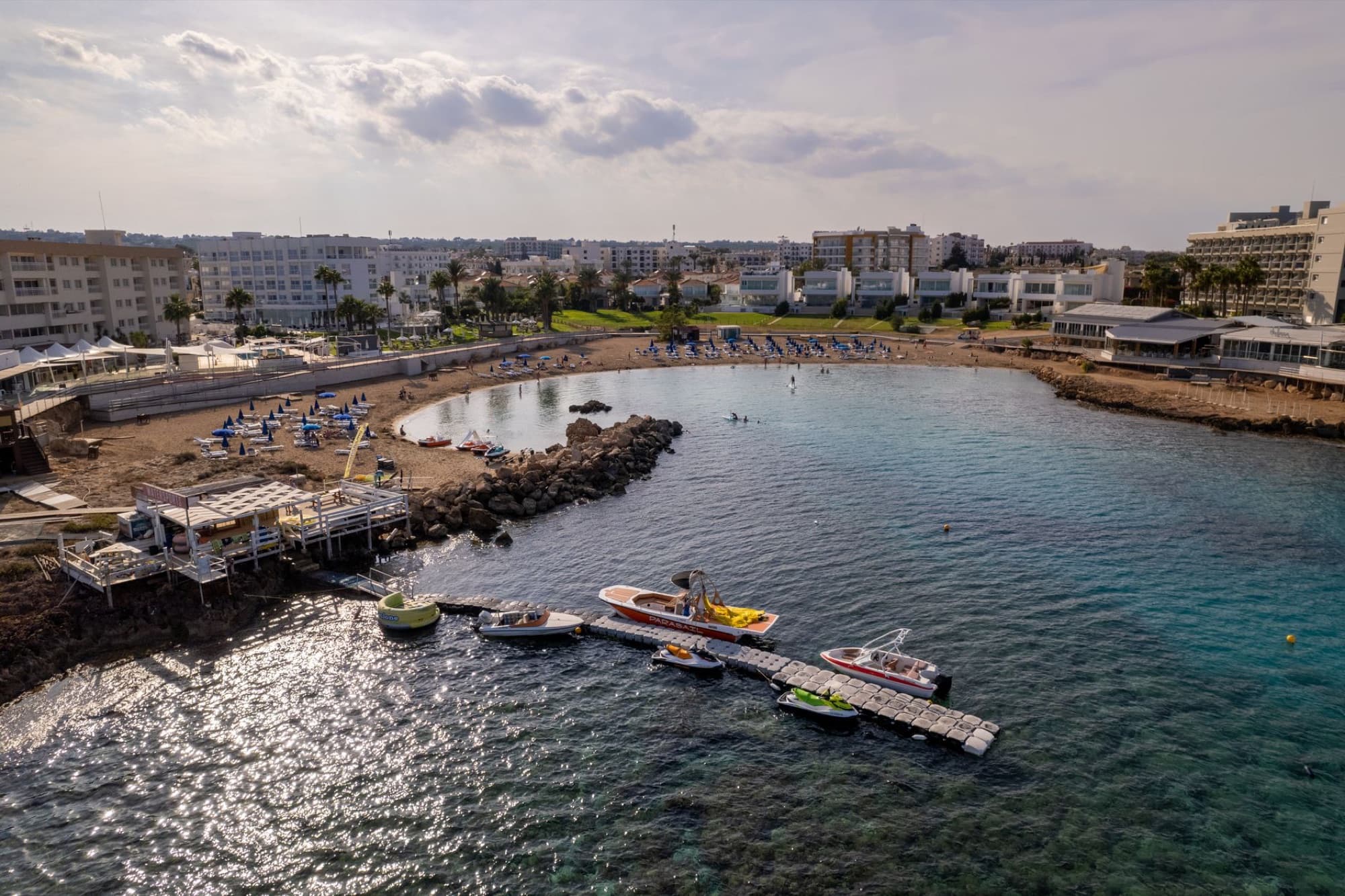 Scenic aerial view of Pernera beach with boats and resort buildings in Famagusta, Cyprus.